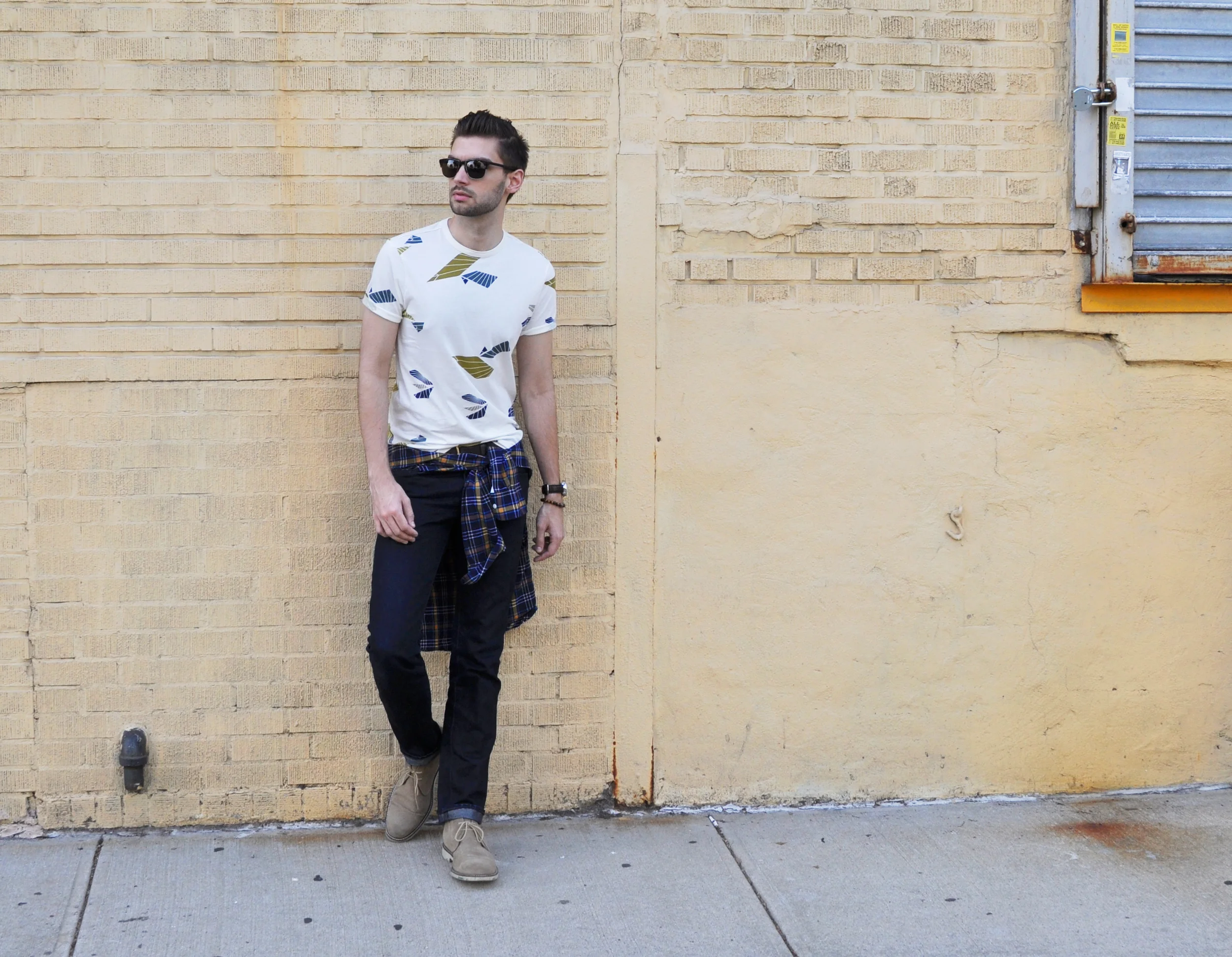 The 90's are back! It's a little grunge but with a new silhouette. Wrapping a shirt or sweater around your waist is a great way to add dimension and color to a look without adding layers. It's easy-going and effortless, just keep your pieces super tailored so you're not straight out of a class yearbook. We're sleeker than we were back then! I didn't go full flannel, but this plaid shirt brings out the print in the tee and helps elevate a basic tee-and-denim look to something a little more interesting. What do you think? Would you wear the look? Ben Sherman t-shirt / J-Crew shirt ( similar ) / Levi's selvedge denim / Banana Republic boots / Warby Parker sunglasses / Coach watch / Ettika bracelet