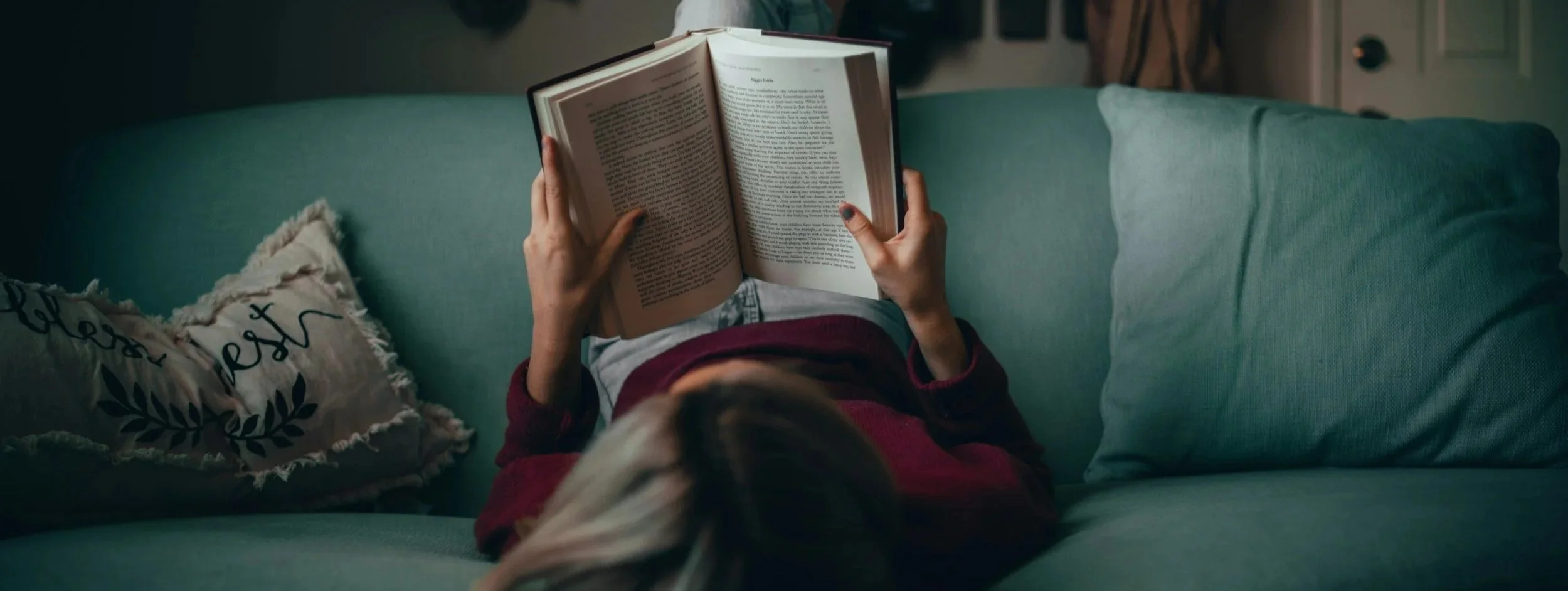 Woman reading a book on a couch