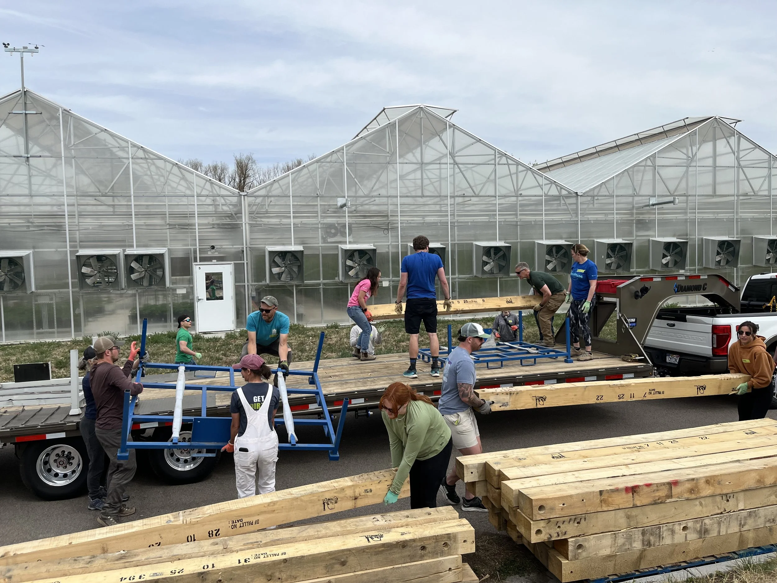 Volunteers moving lumber at a volunteering event.