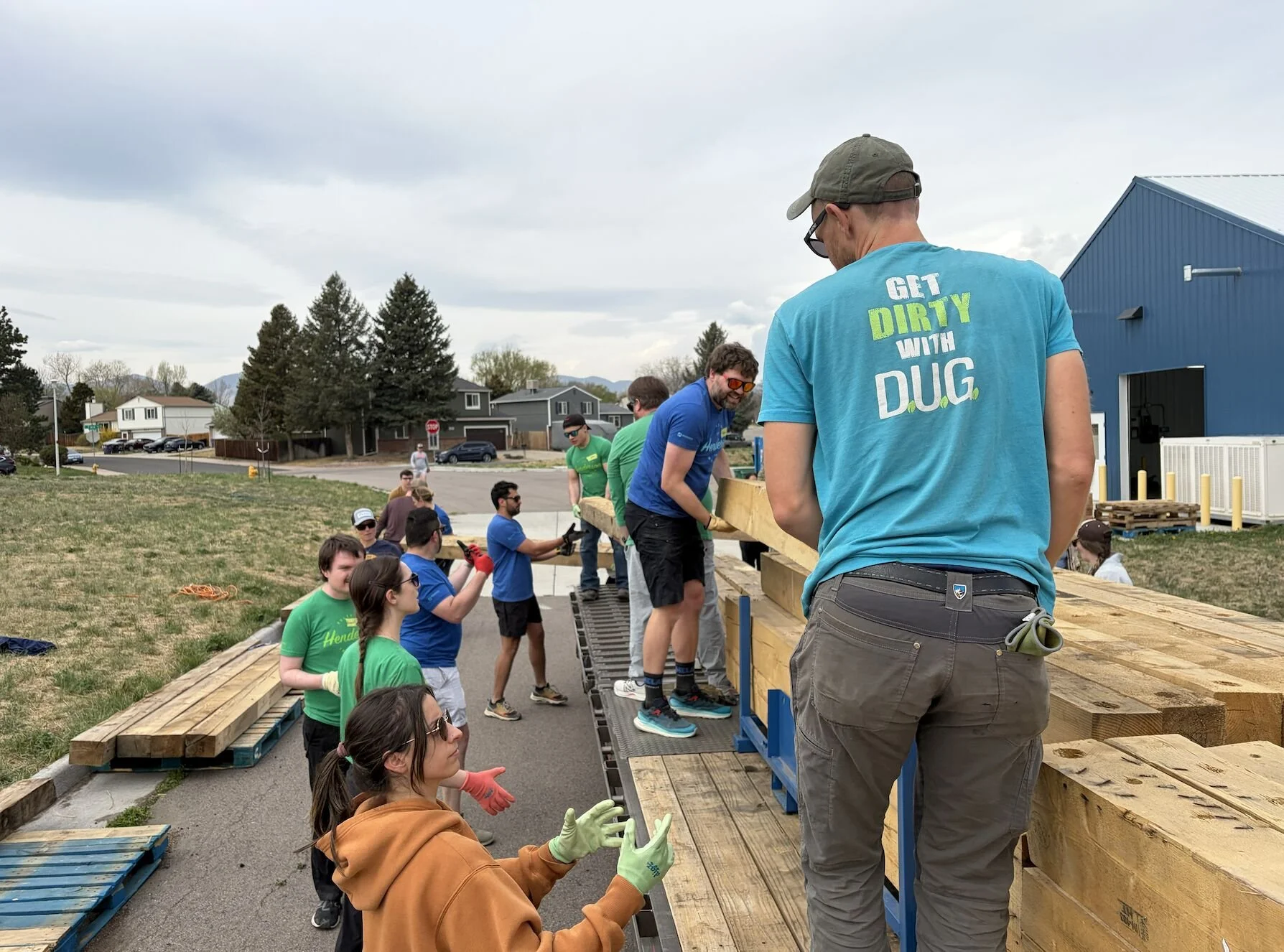 Volunteers lifting lumber at a volunteer event.