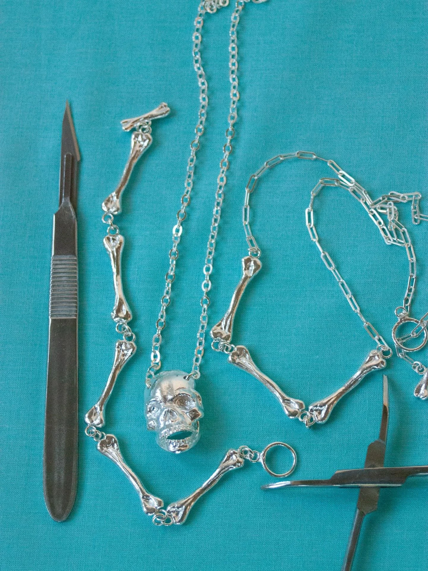 💀 🦴 In honor of Spooky Season, here are some of my fave skulls and bones I&rsquo;ve made over the years. All of the blue background pics are from my Anatomy Collection, the skull with pearl teeth is the Hades necklace from my Siren Collection, and 