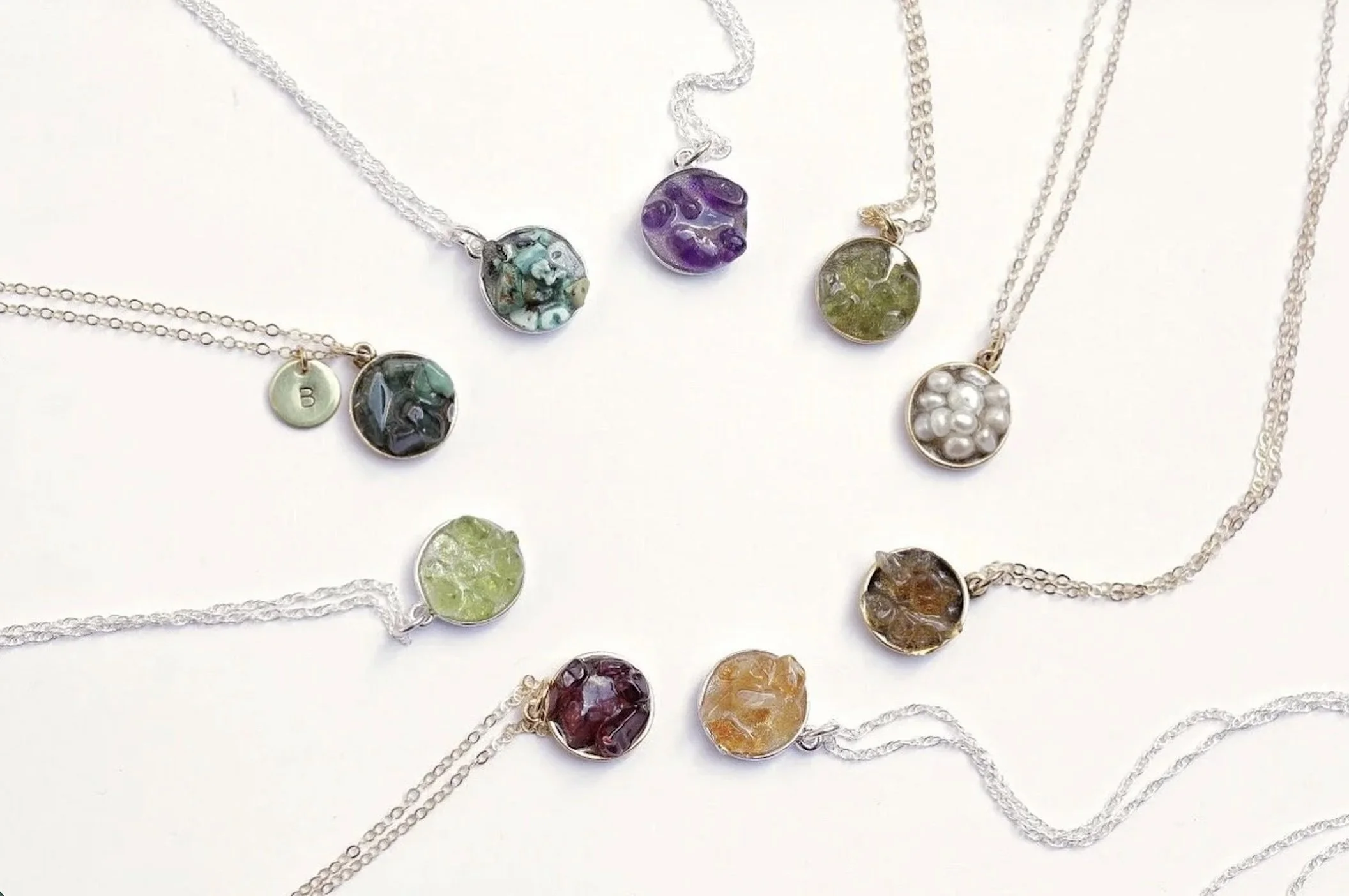 A circle of pendants on chain. The pendants are roung clusters of various birthsones.