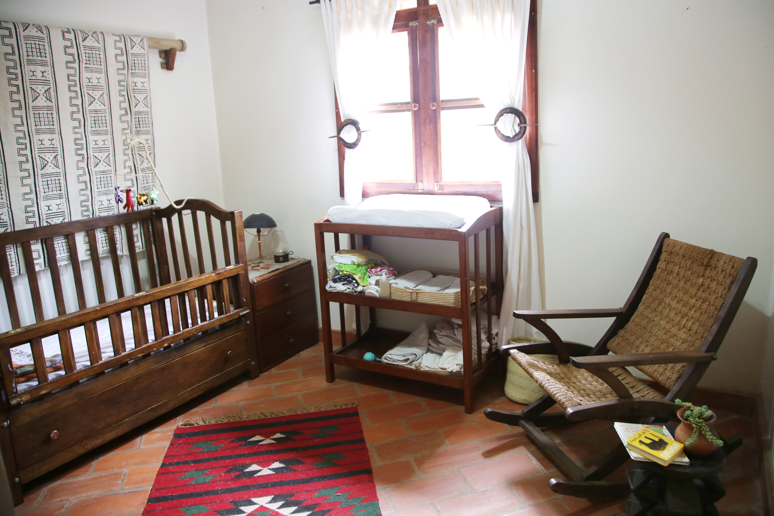 Crib, changing table, and rocking chair all made locally and bought second-hand. Mudcloth wall hanging from Mazmoon's Treasures. Rug bought on a trip to Jordan.