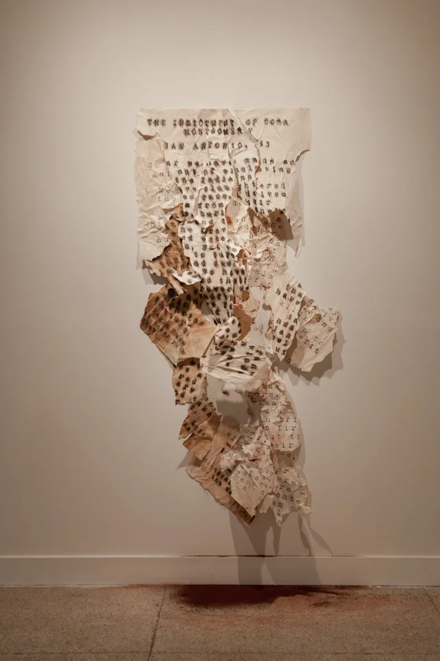 The Indictment of Cora Montgomery. 2015. Exhibit and installation. performance relic, paper, red pigment. Guadalupe Cultural Arts Center