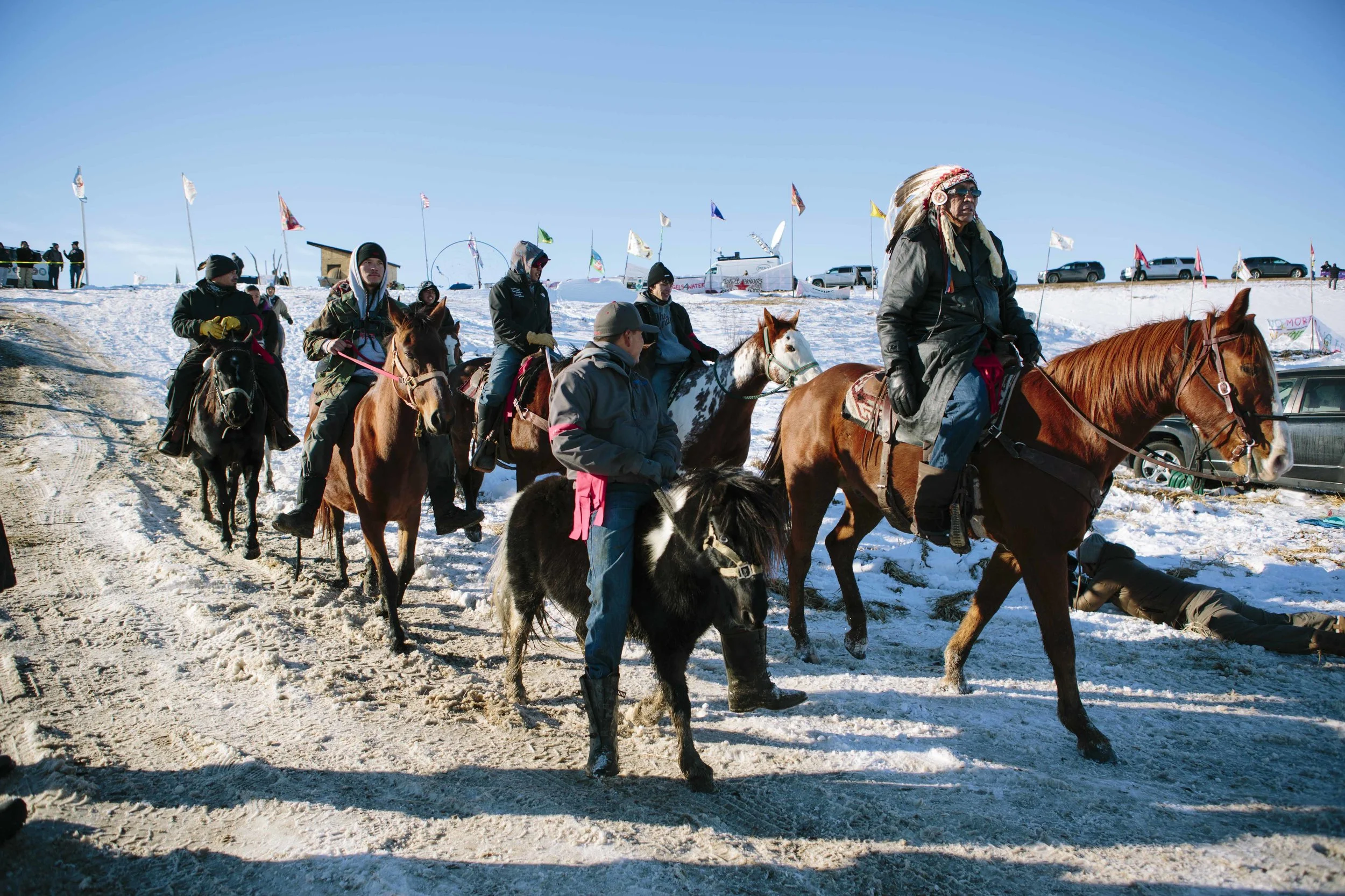 Lakota tribesmen enter Oceti Sakowin on horseback