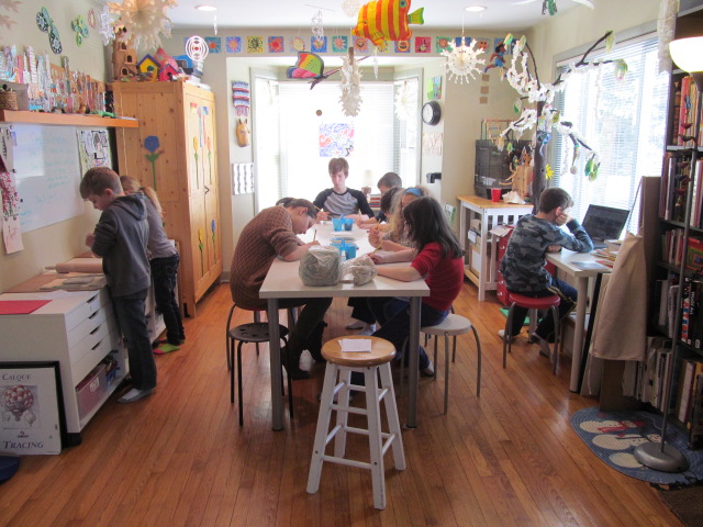 The studio on day 2: clay slab rolling station on left, clay building at the center tables, and research station on right for sketching.