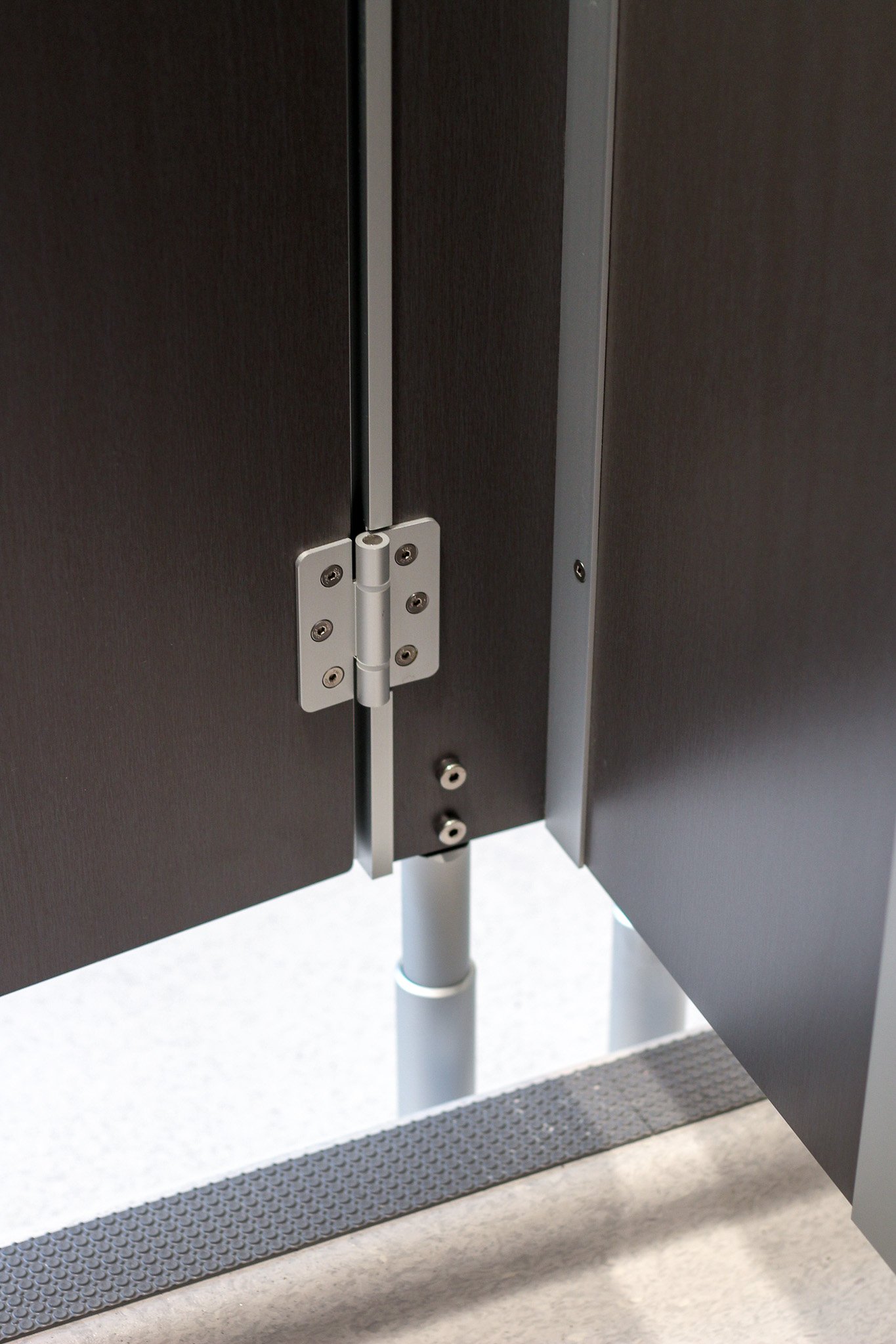 Image from the inside of toilet cubicles showing the hinges and feet