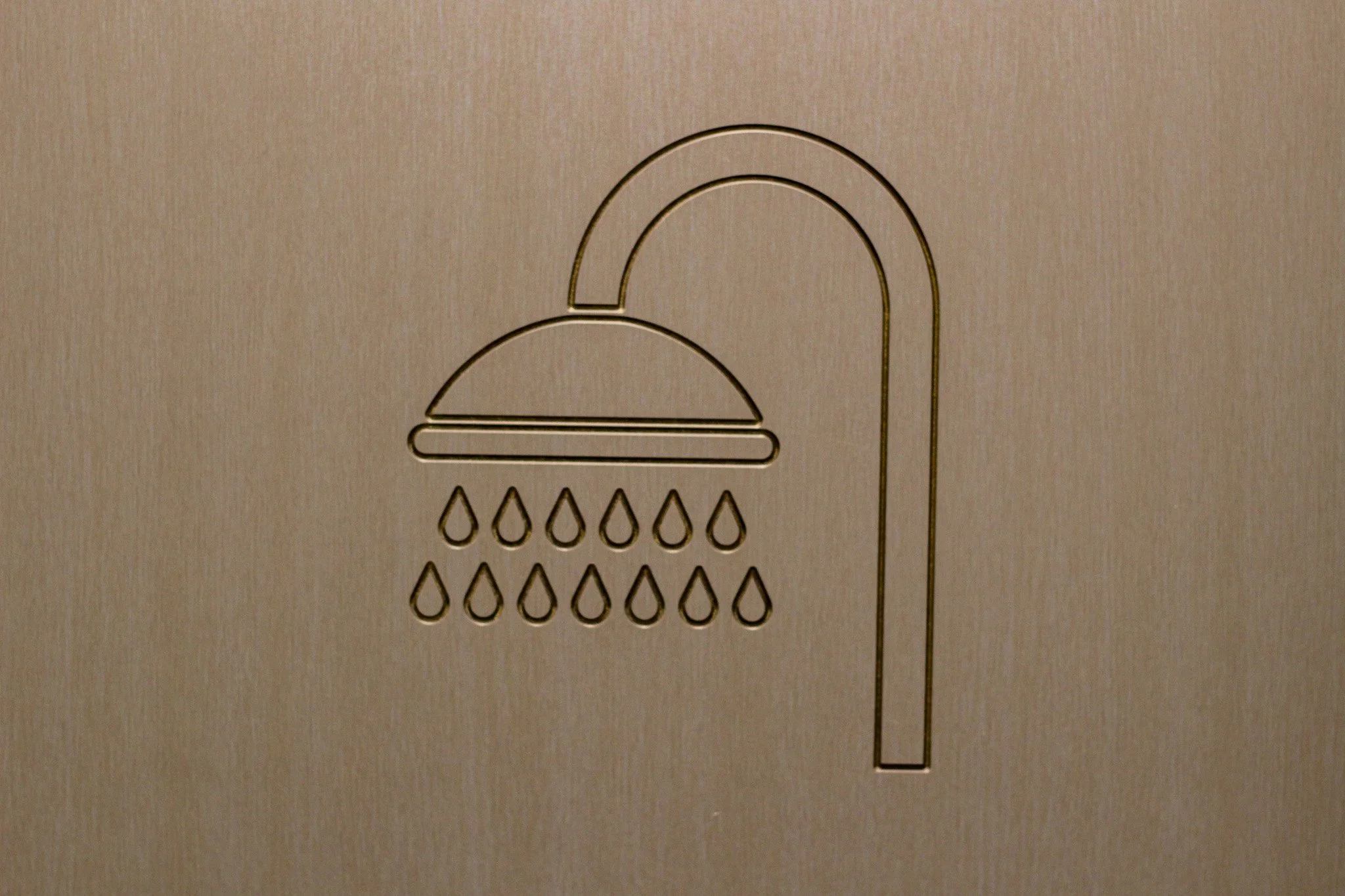 Icon of a shower, had been CNC into the door of a shower cubicle