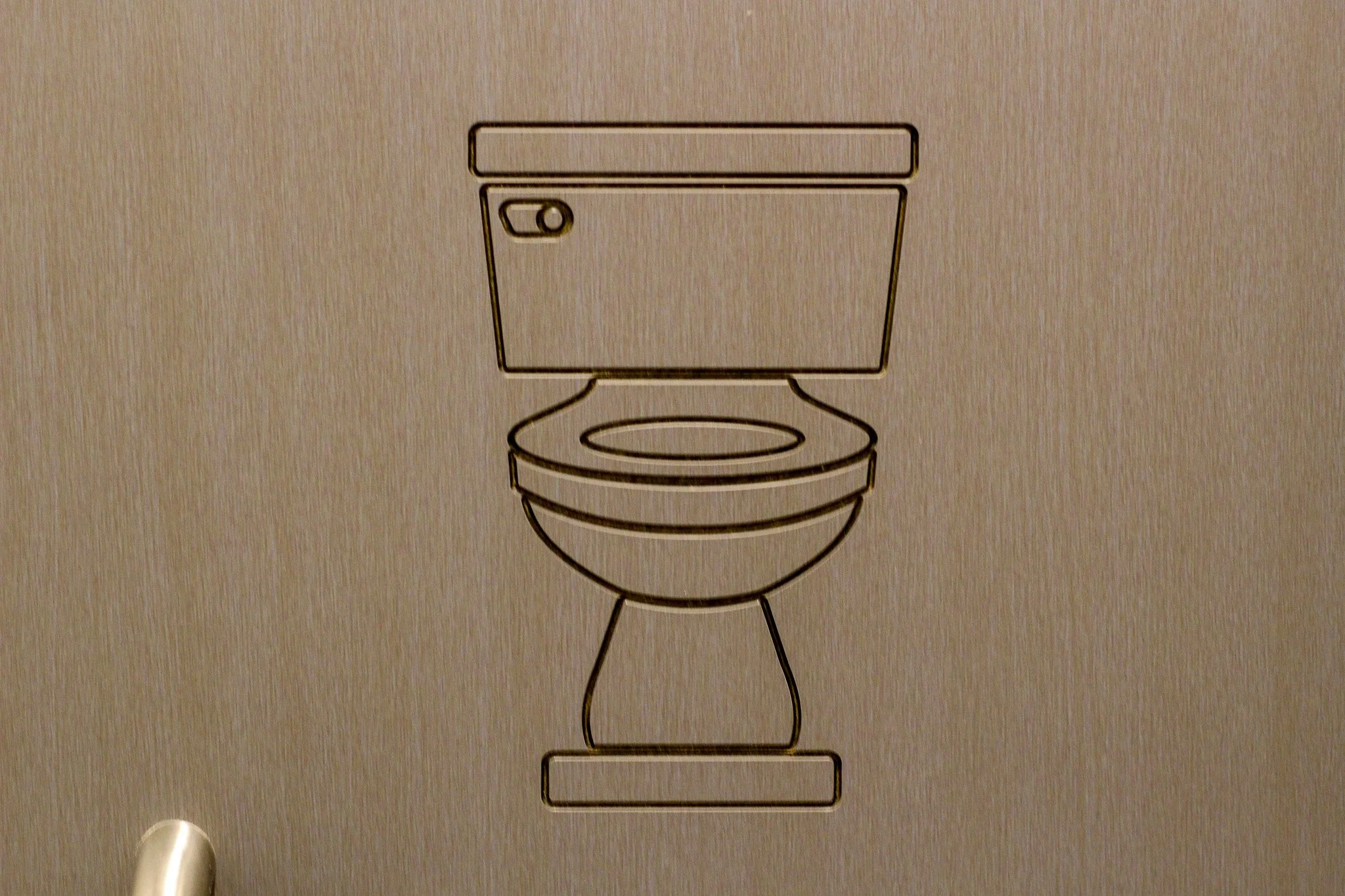Toilet icon that has been CNC into the compact door