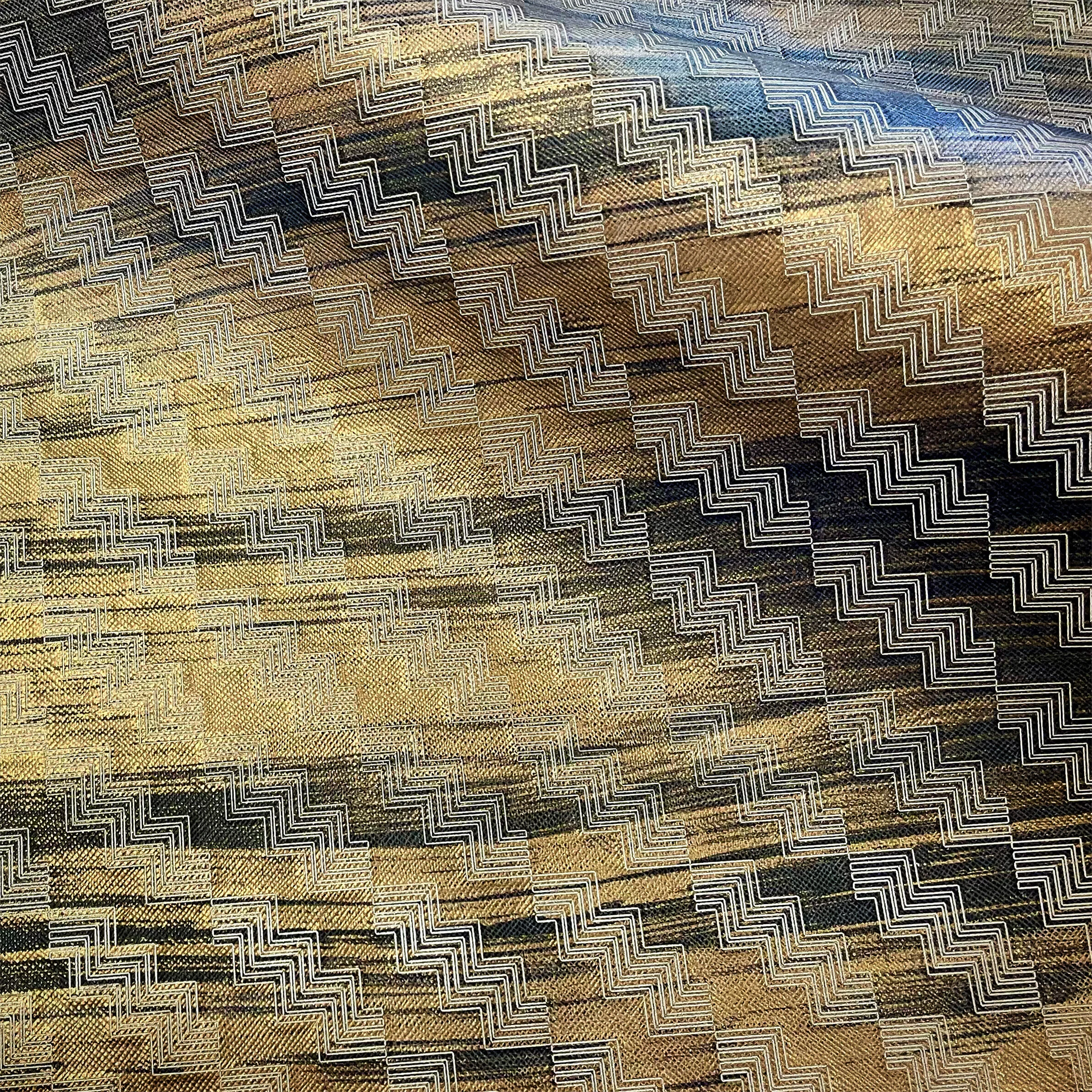  etched on morel embossed leather in black with mondo bronze paint and white wash fill 