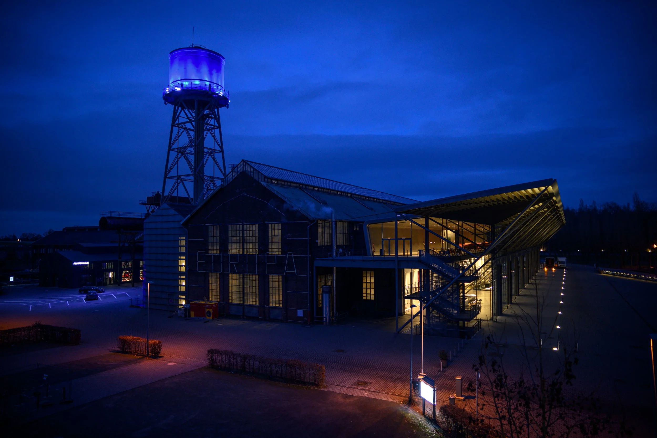 Wasserturm (beleuchtet) und Jahrhunderthalle im Bochumer Westpark.