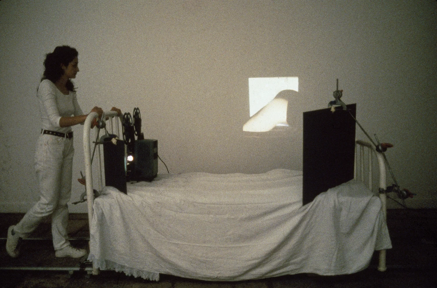 Eulalia Valldosera, Embenatges - Bandages, 1992 16 mm film projector, film with soundtrack, 18’; individual hospital type bed; 2 mirrors; rails and dolly for traveling shots Performance