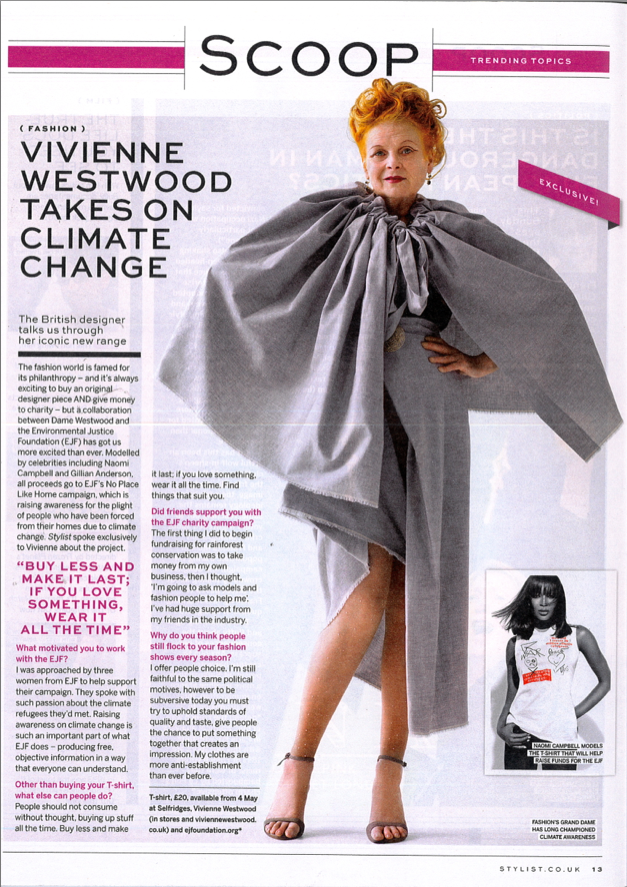 Woman with red hair wearing a large gray cape, standing with one hand on her hip, in front of a fashion magazine page about climate change and charity work.