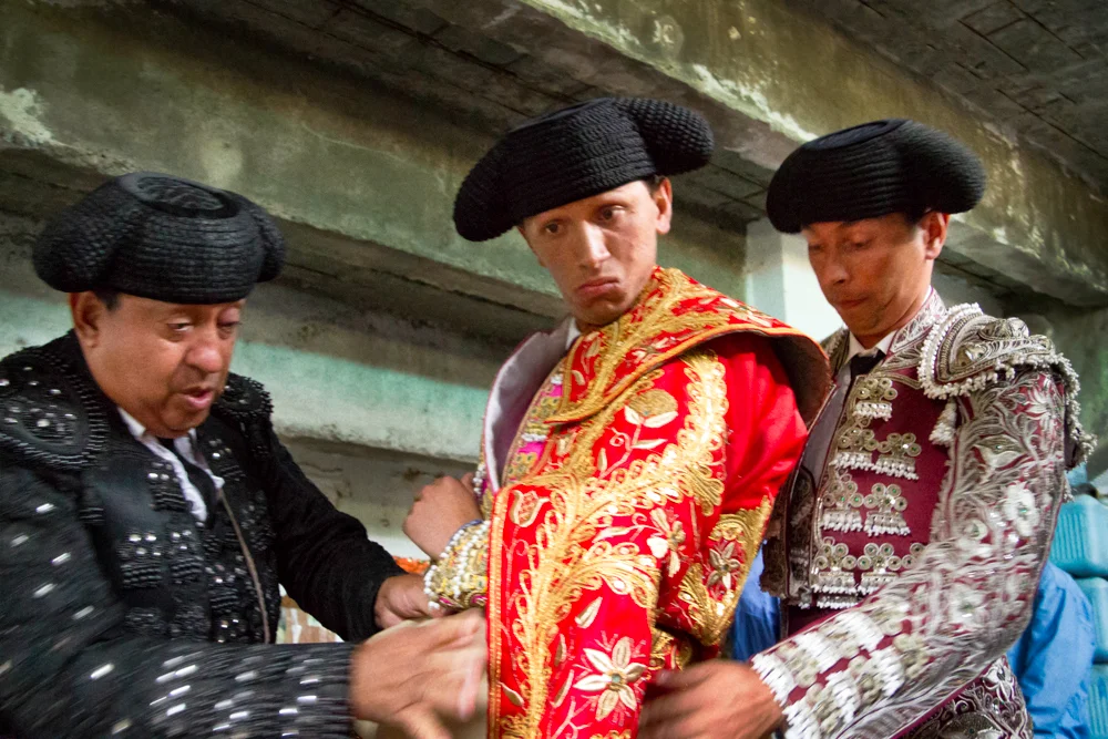 Two senior bull fighters help to prepare a young man who is just beginning his career. In this series I photographed several young men who were training to become bull fighters in a small town called Choachí on the outskirts of Bogota, Colombia. They were committed to pursing this tradition, something they see as an art form, despite enduring an increasing amount of scrutiny from animal rights activists and an uncertain future. 
