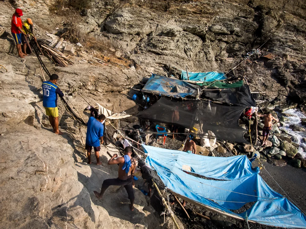 The fishermen stretch the net out for repairs. In this series, I photographed the daily happenings of a group of fishermen in the small town of Taganga, on the northern coast of Colombia. They use a simple yet effective method, common of indigenous groups, that has been passed down through generations. Their connection to the sea and their commitment to this way of life persists despite the amassing threats of pollution and over-fishing by commercial enterprises.
