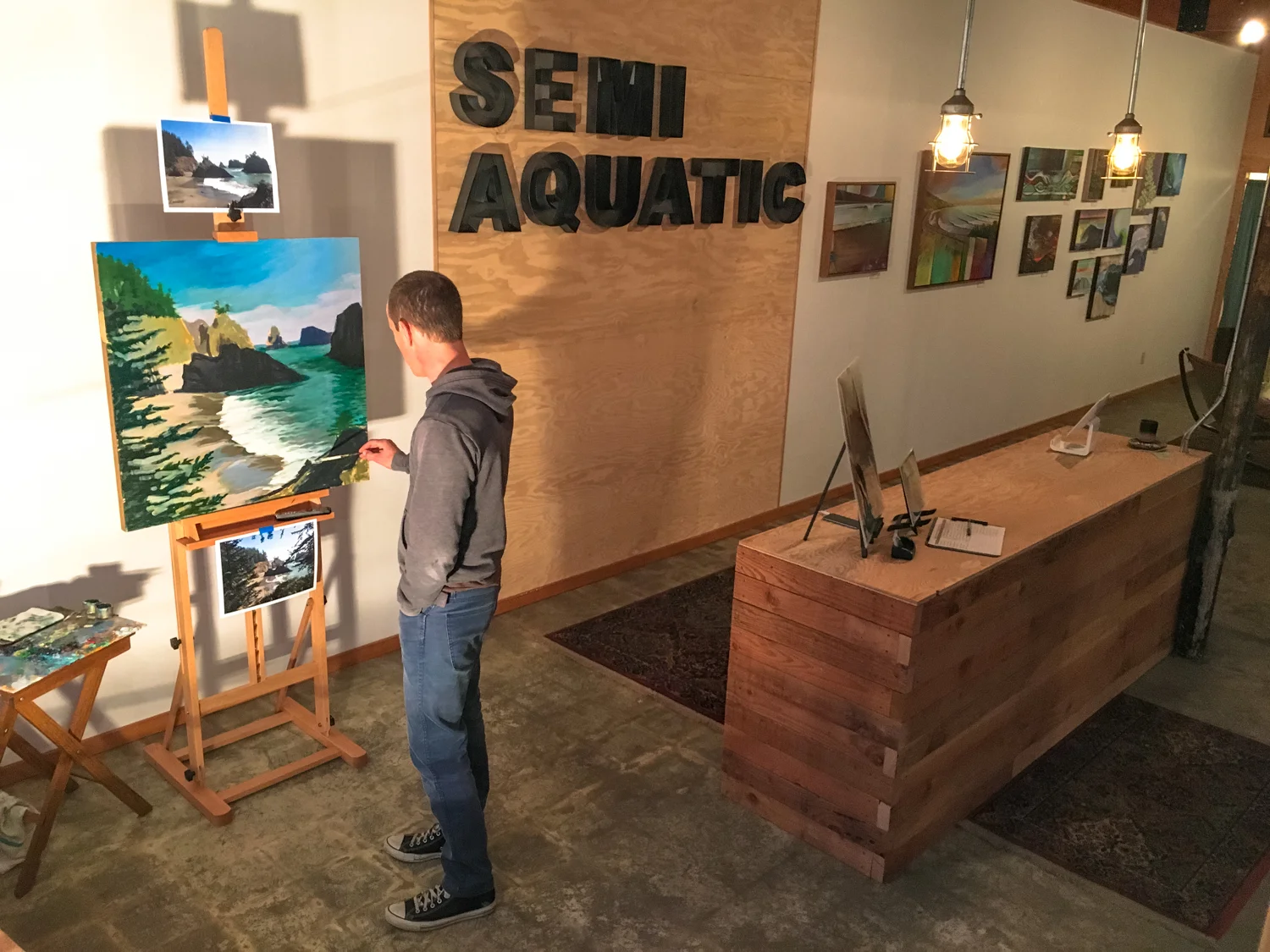 Spencer Reynolds painting Secret Beach in his new Brookings gallery, December 8, 2015. Photo: Kew.