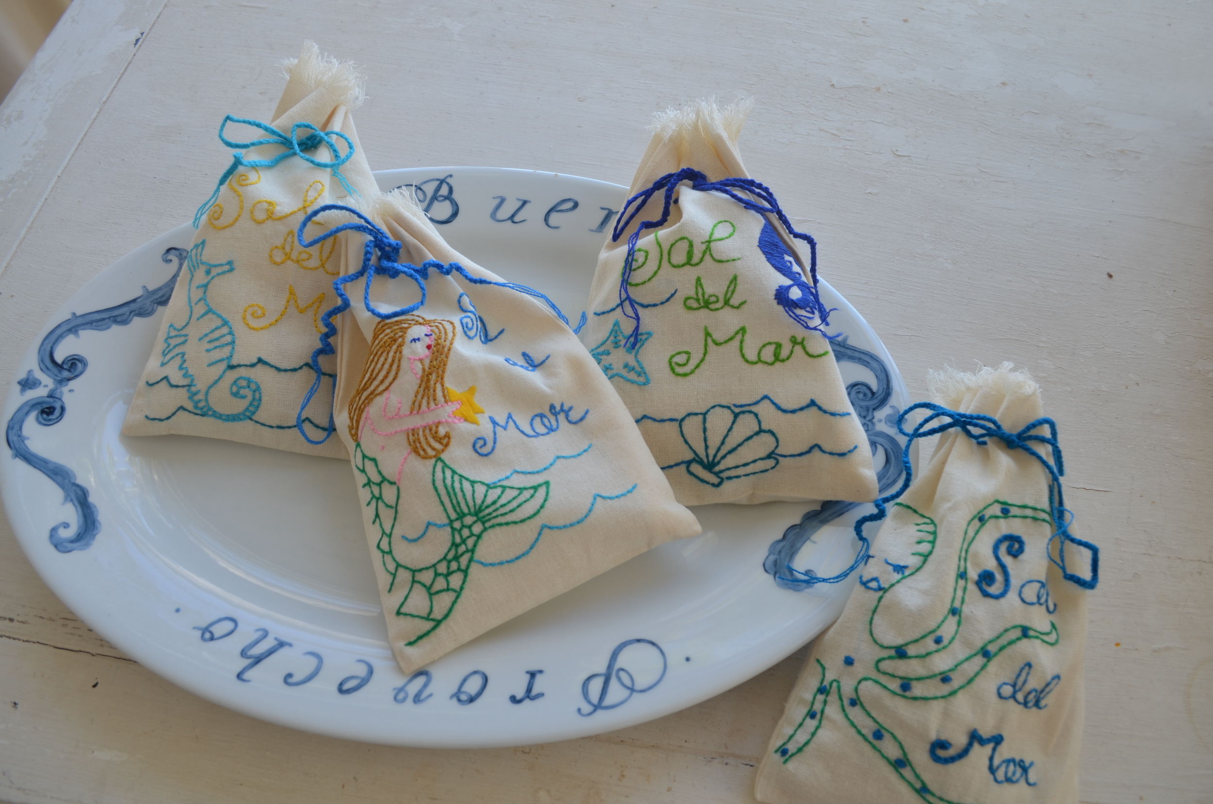 We have added four new designs to our Sal del Mar hand-embroidered bag line. With summer here already, we thought Creatures from the Sea would be a perfect look and came up with whimsical designs that we named...“Inky the Octopus,” “ Star the Mermaid,” “Saucy Seahorse,” and “Sea Shells.” We chose sea colors of greens and blues. We love the way the embroiderers made them come alive with their artistic way of interpreting our designs with their needle and threads. They will make the perfect gift to take to all the summer barbeques. See them on our shopping page with all of our other Sal del Mar designs. 