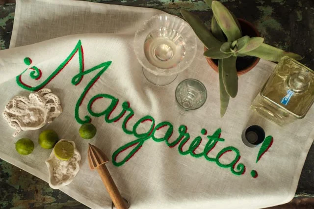 Of course, you can even find a place on the countertop in the kitchen and try out the Margarita bar towel with its magnificent sprawling letters in lime green. You will set out your beloved tequila. Set out limes, a shaker and martini-styled glasses rimmed with our Sal del Mar gourmet sea salt. And voila!