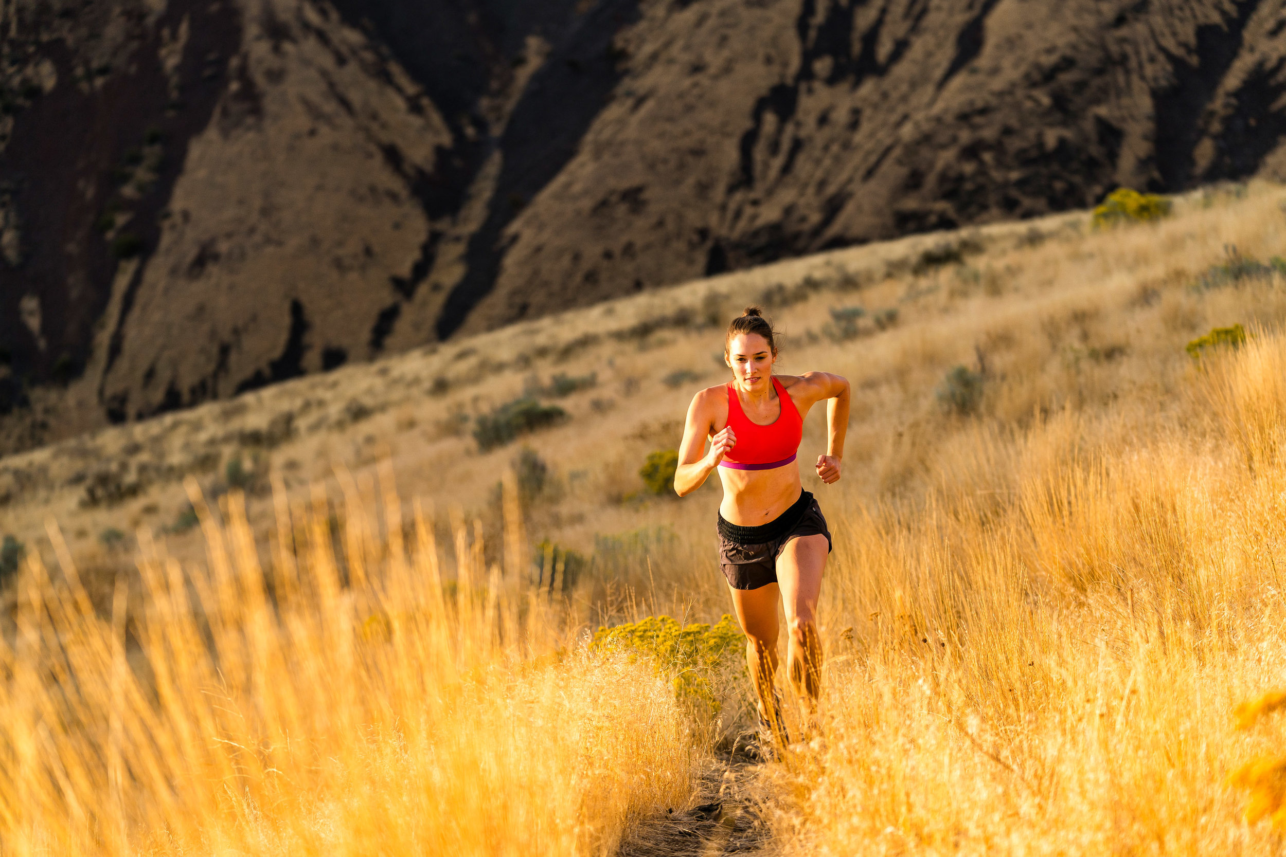  Adventure: A young woman trail running in late summer in Yakima Canyon, Washington 