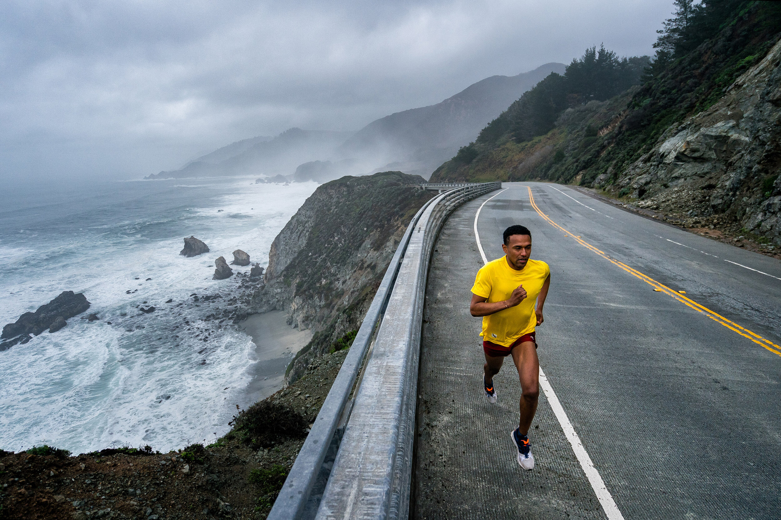  Adventure: Tim Cummings road running on a stormy day along the Big Sur Coast, California 