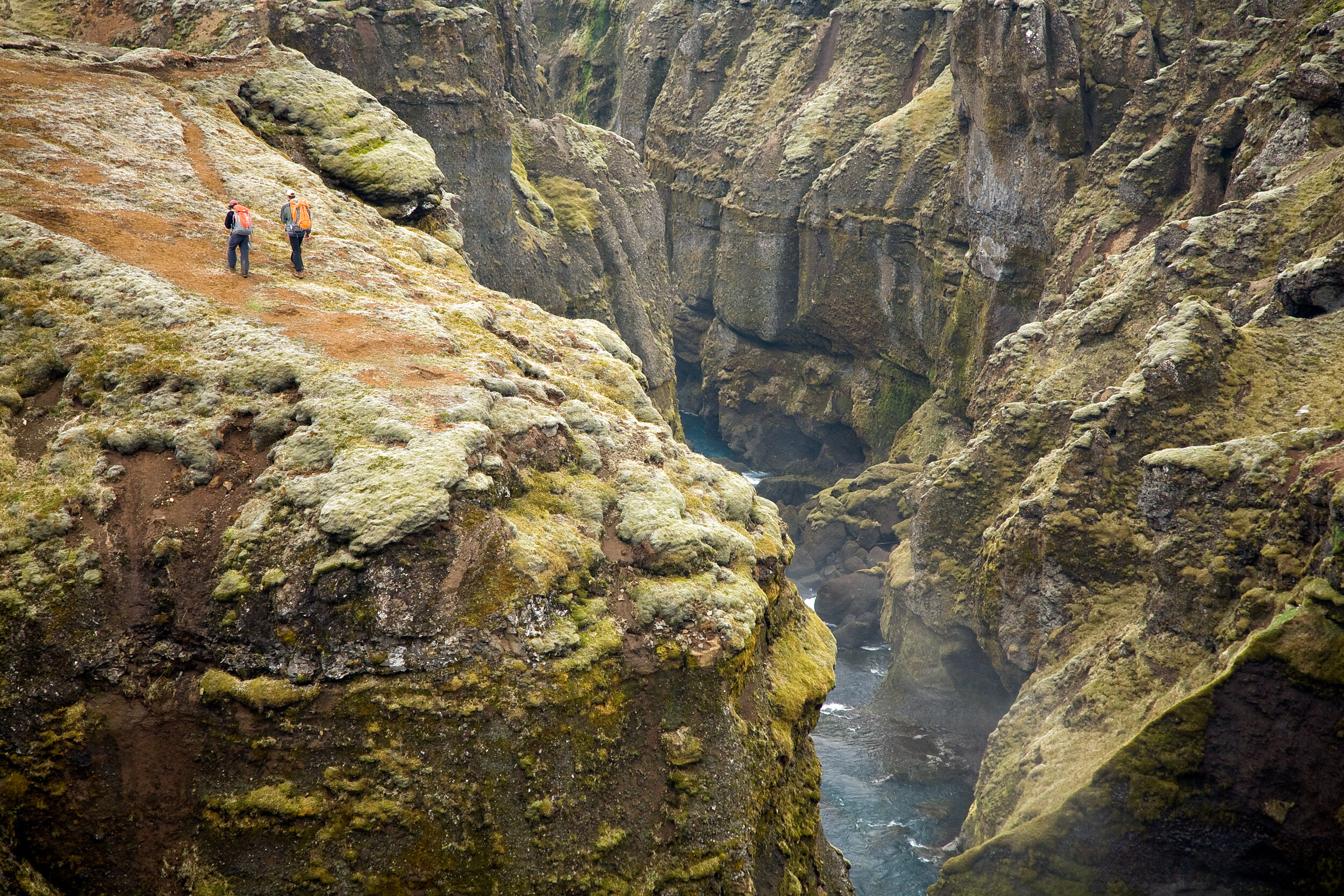  Adventure: Hikers take in the views of a deep gorge, Skogaheidi, Iceland 