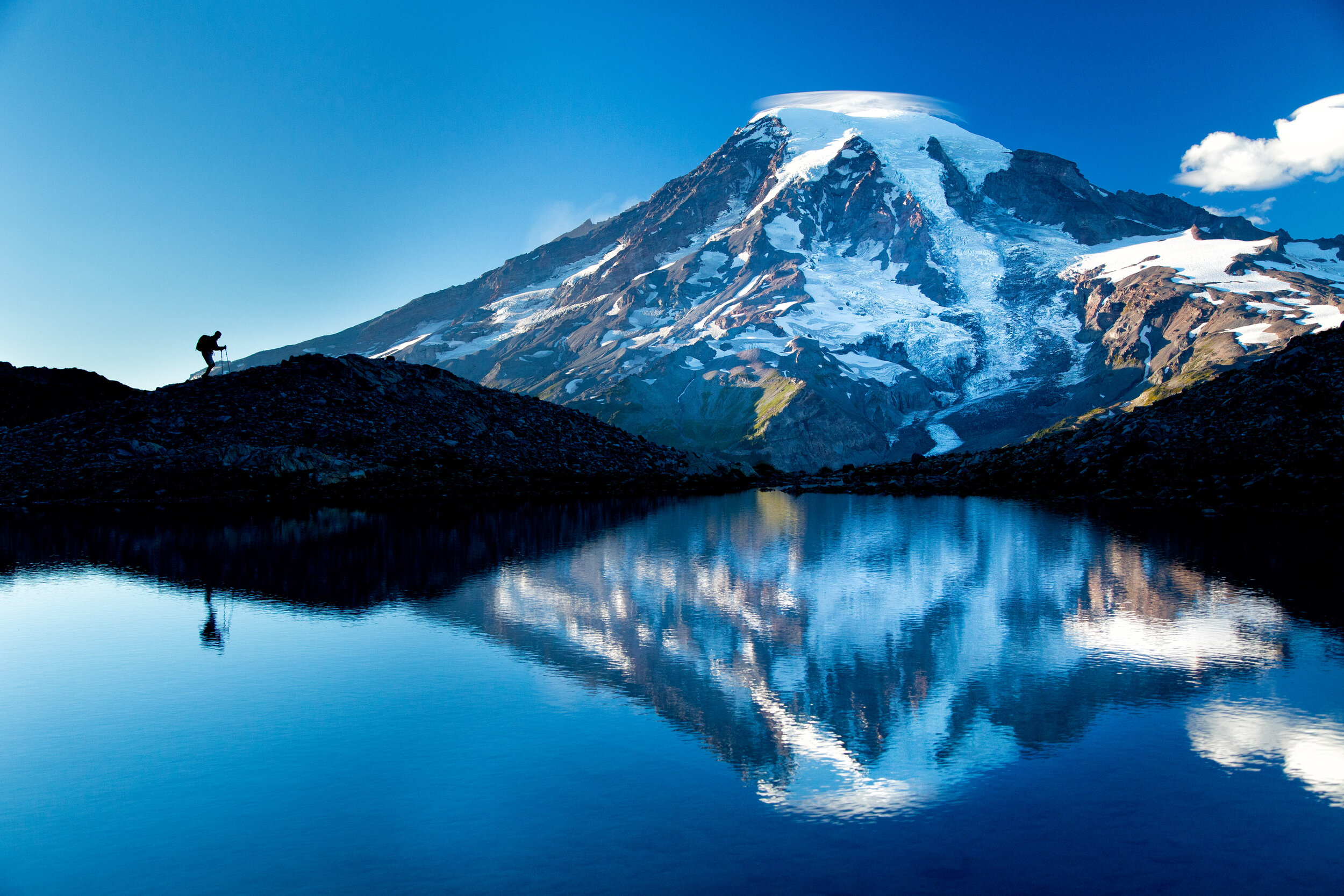  Adventure: A man hiking near a lake below Mt. Rainier at sunset in summer, Mt. Rainier National Park 