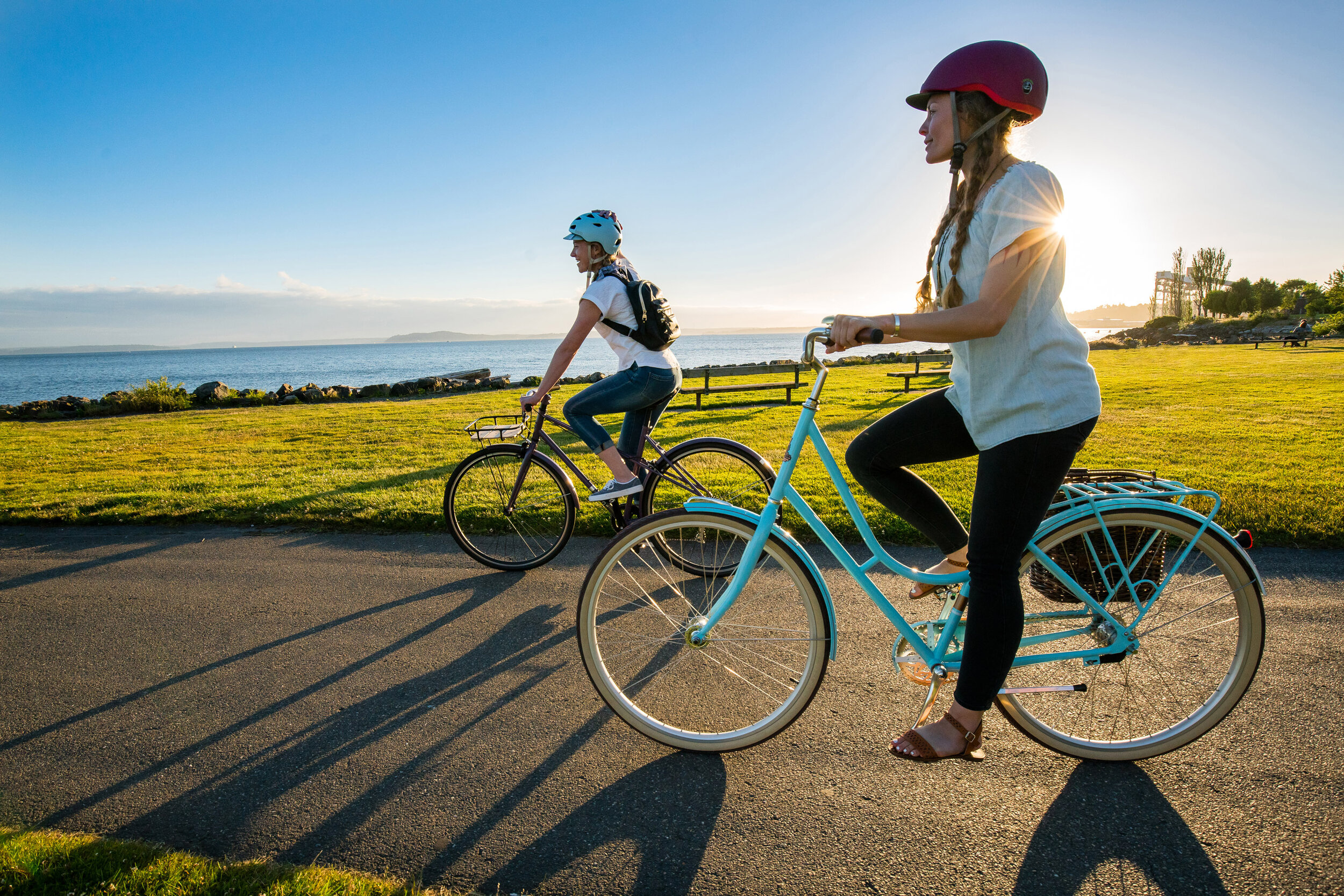  Lifestyle: Leasle Crawford and Tayler Vandy ride cruiser bikes along the Seattle waterfront in summer, Myrtle Edwards Park 