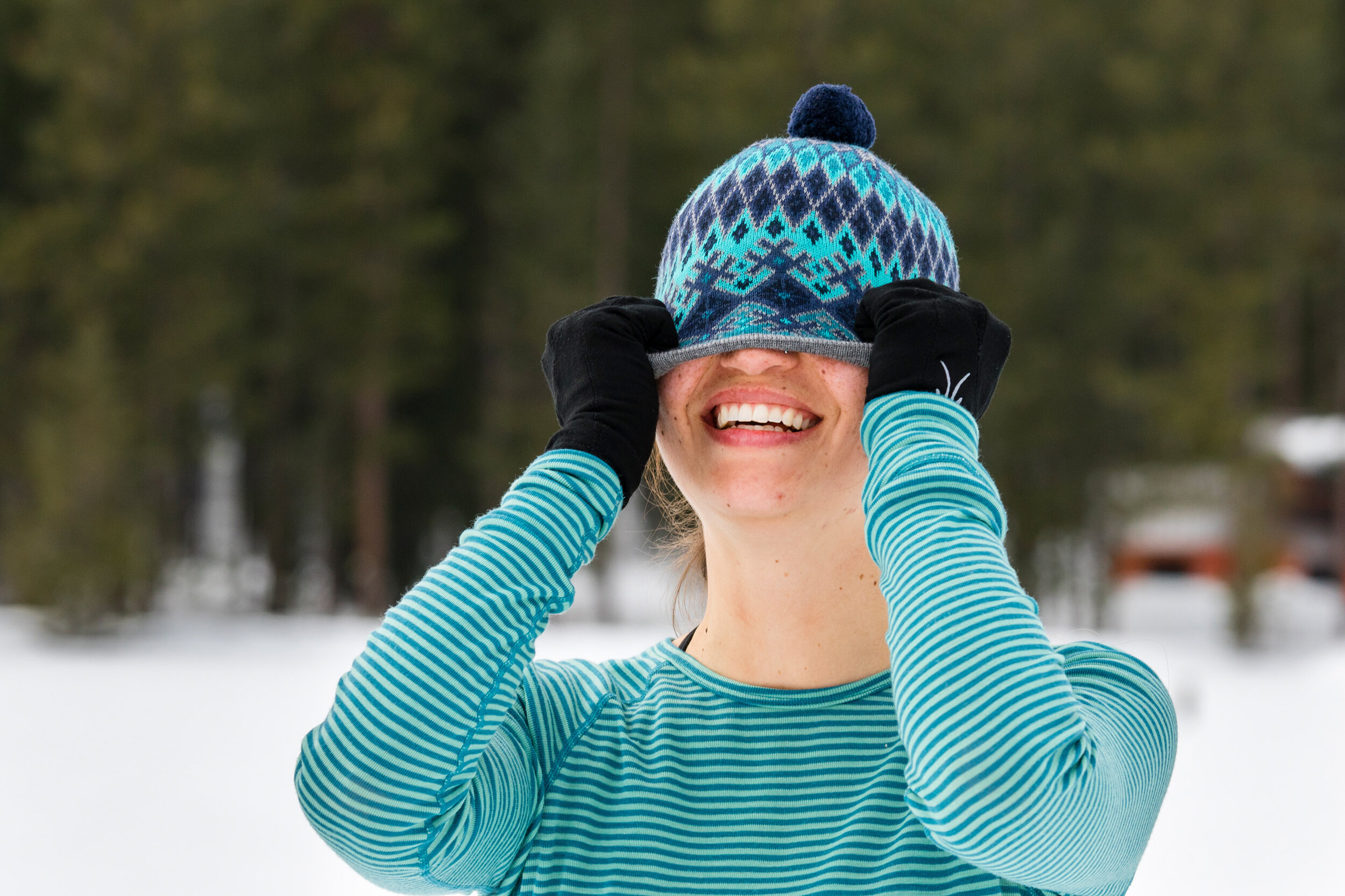  Lifestyle: Nicki McClung playfully covering her face with her winter hat, Mazama, Washington 