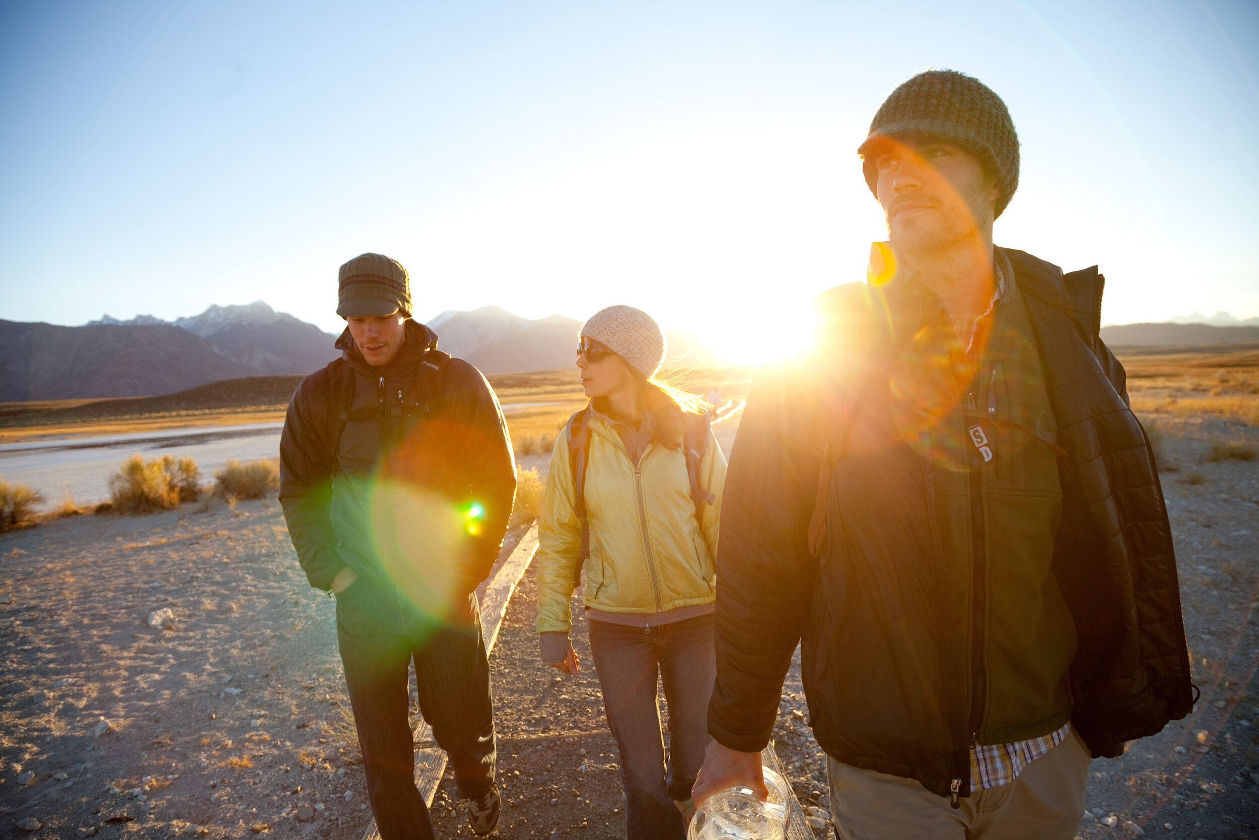  Lifestyle: Three friends walking to a natural hot springs at sunset, Owens Valley, Eastern Sierras, California 