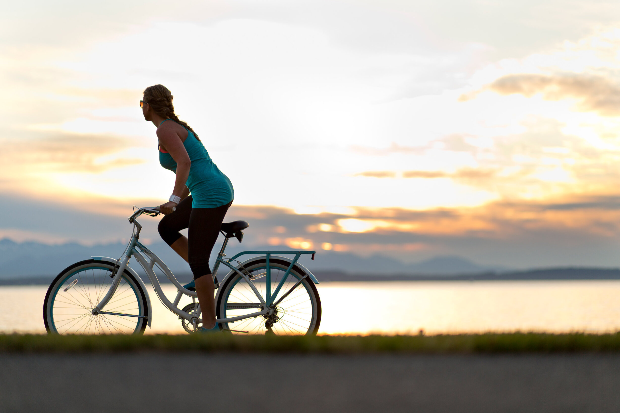  Lifestyle: A young woman riding a cruiser bike at sunset, Alki, West Seattle 