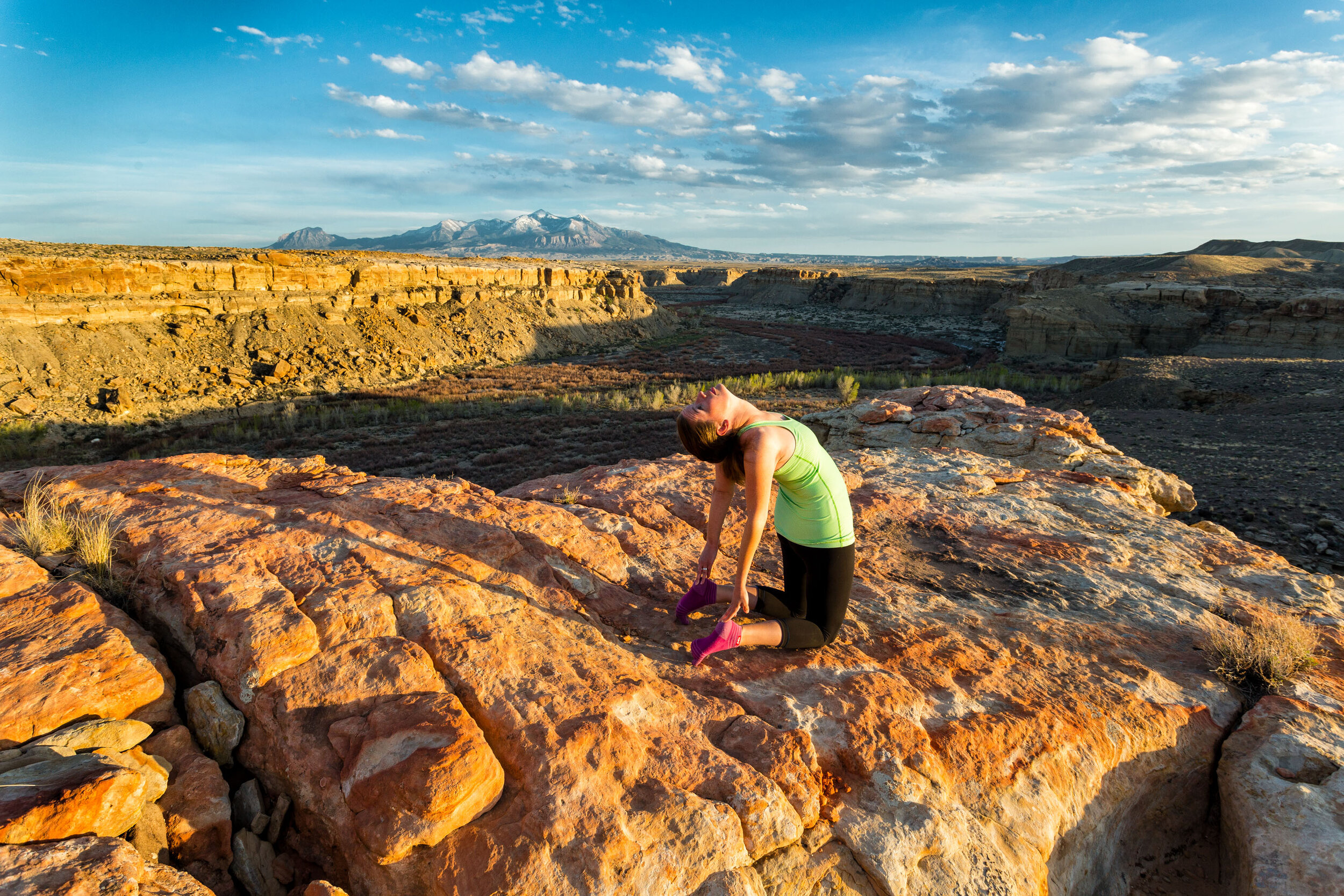  Lifestyle: Melissa Hagedorn doing yoga below the Henry Mountains at sunset, Cainville, Utah 