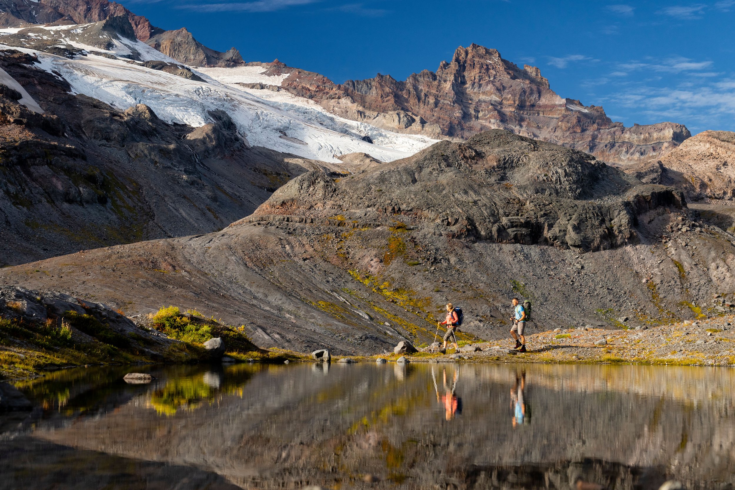  Adventure: A man and woman hiking in the Mt. Rainier backcountry in late summer, Mt. Rainier National Park, Washington 