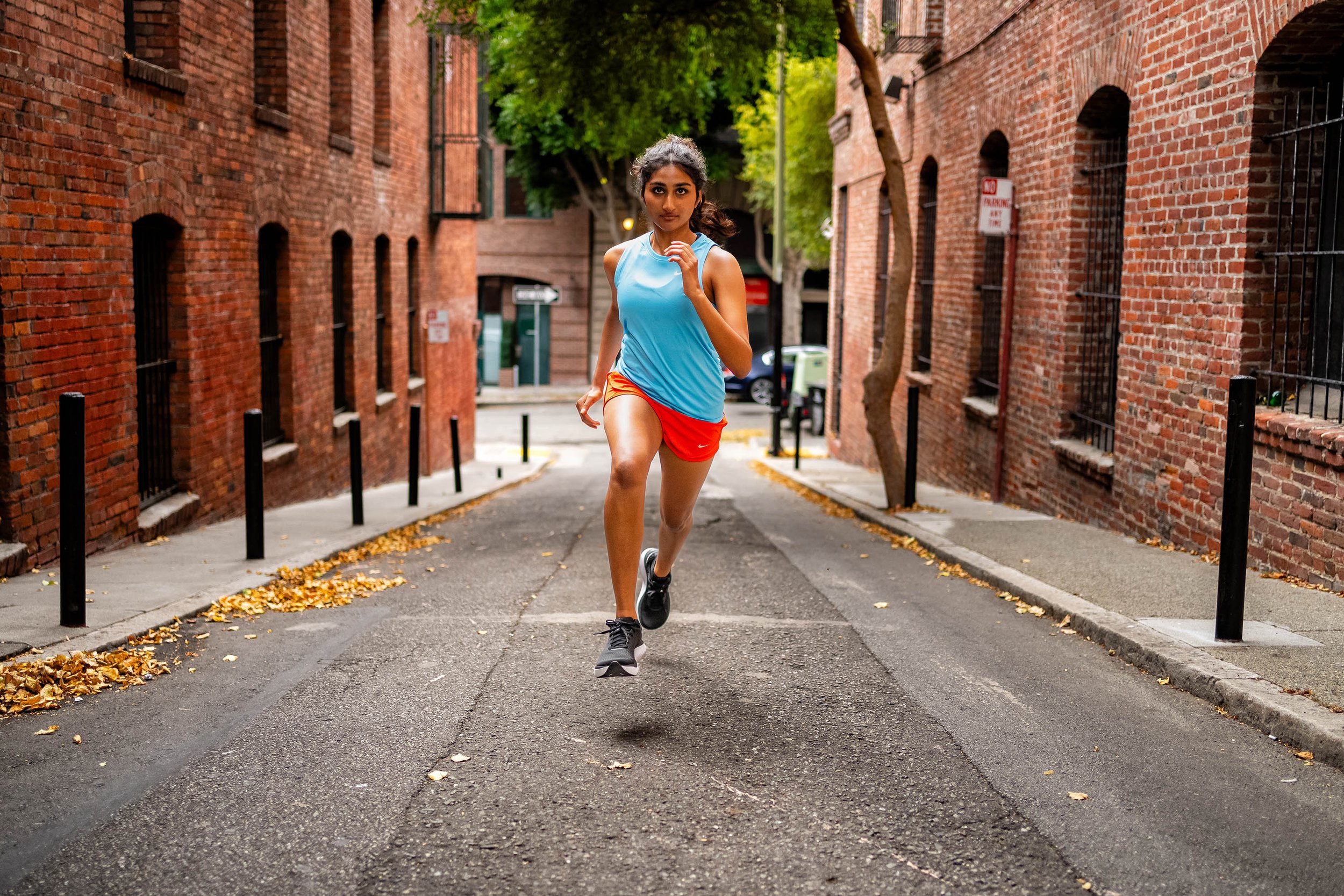  Fitness: A young woman running up an empty alleyway, San Francisco California 