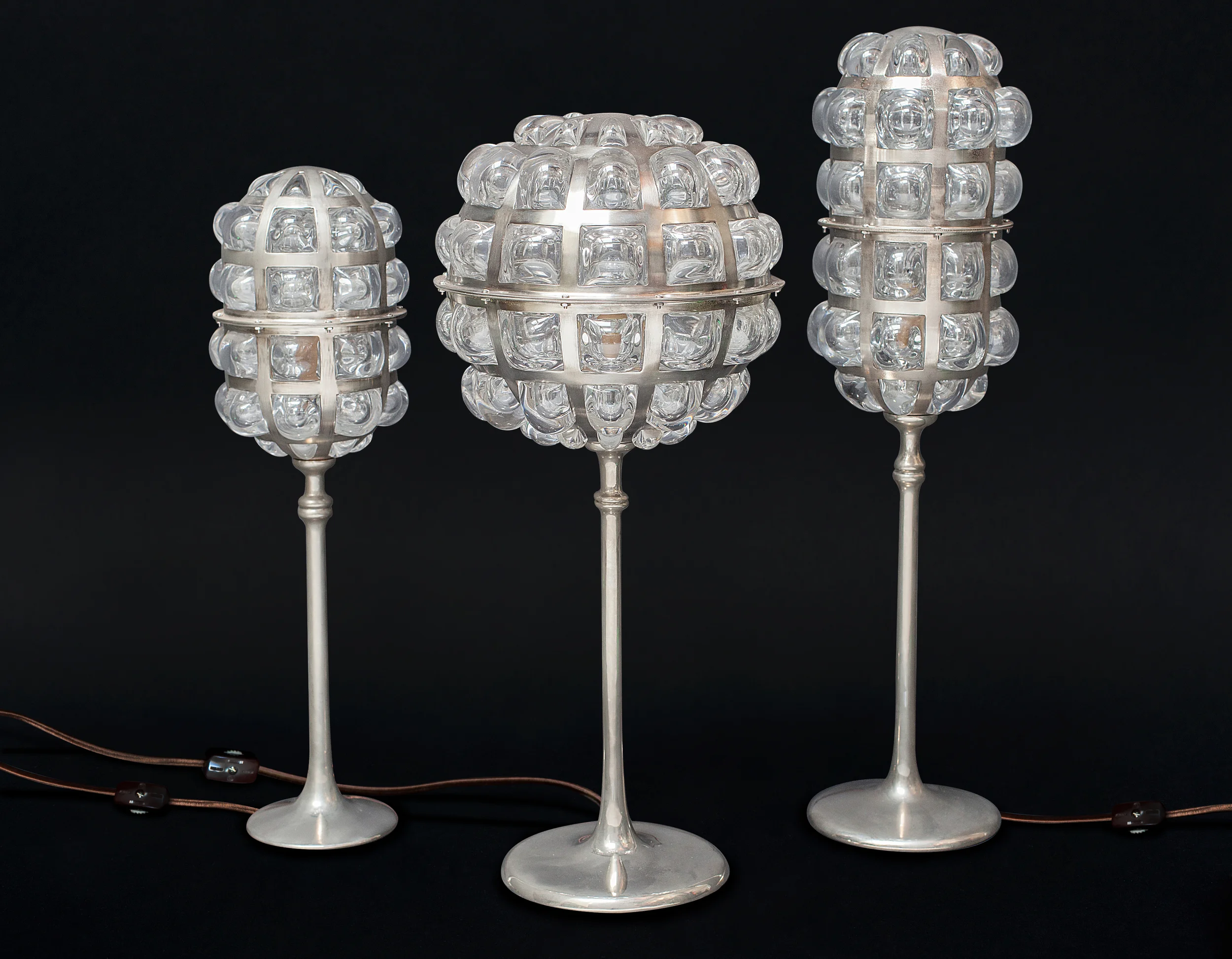 Made from cast bronze, copper and blown glass. This trio is nickel plated. From left to right, 16"H 17"H 19"H