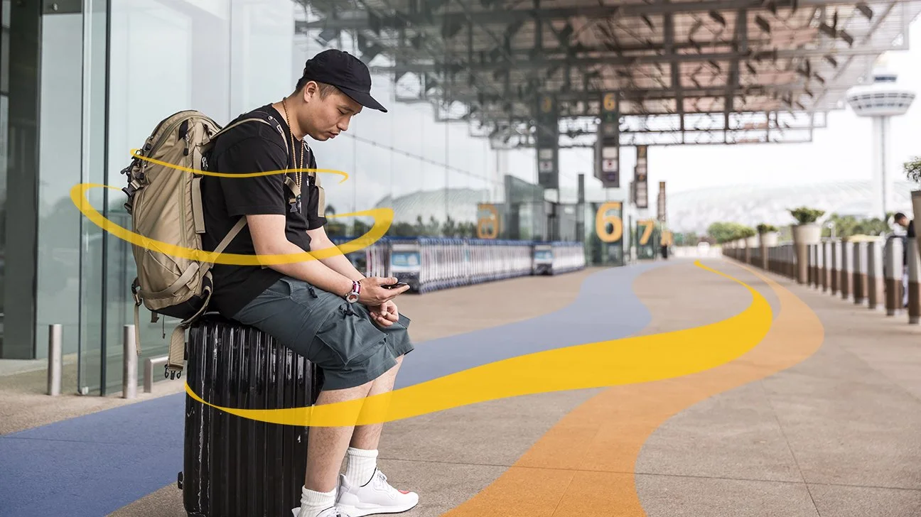 man-sitting-on-suitcase-luggage-airport-waiting-1296x728-header.jpg