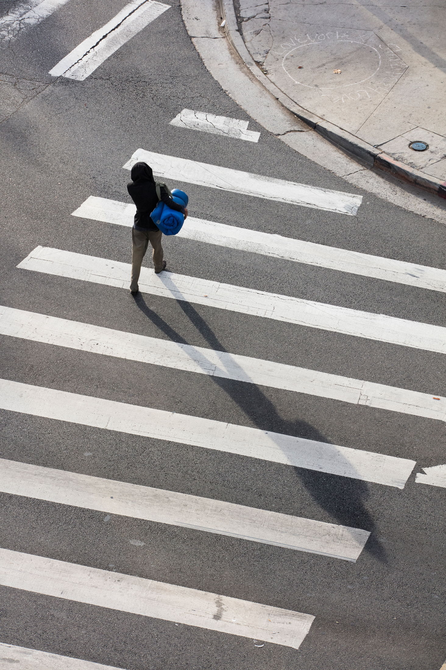 Nic Dumay crosses a busy intersection at Van Nuys and Ventura Blvd. walking in the direction of a Starbucks that he spends his mornings in.
