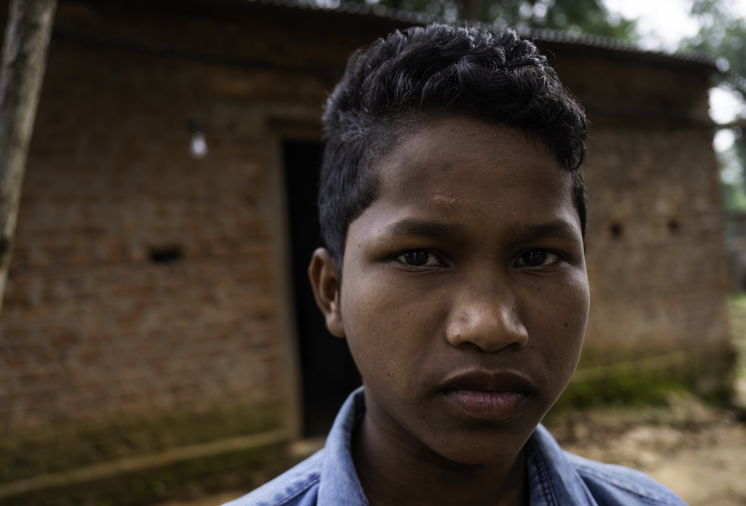   A young orphan in Kandhamal India stands in front of the schoolhouse where he learns and sleeps in. During the Summer of 2008, his parents were killed by Hindu nationalists because of their Christian faith. He and many other orphaned children have 