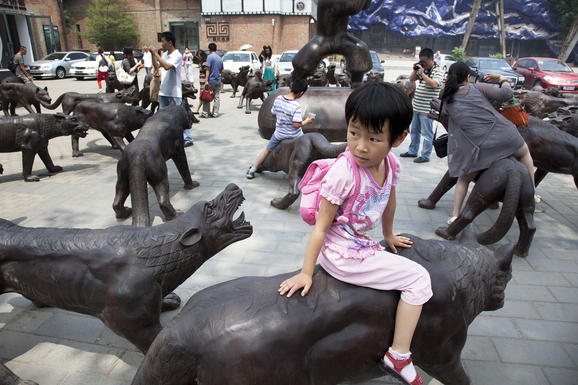  Kids playing on some bronze wolf sculptures at 798 Art Zone or Dashanzi Art District. 