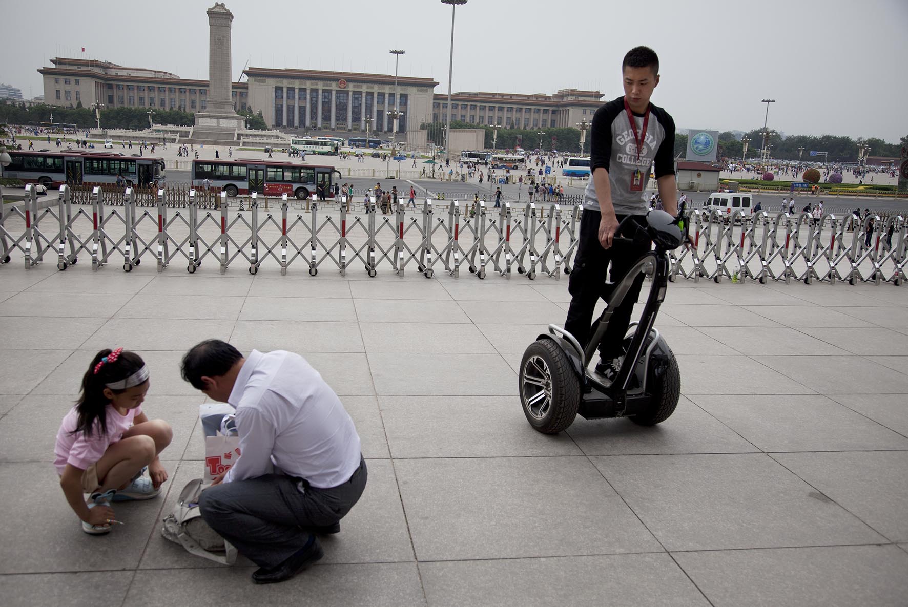  Man policing the public on a Segway two wheeled vehicle outside The National Museum of China. 