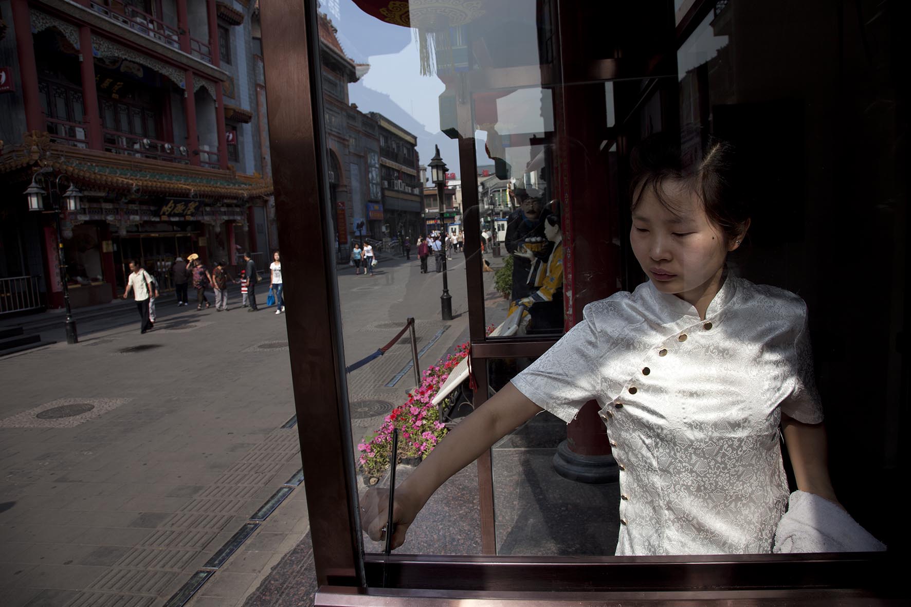  Waitress cleans the windows of a Chinese restaurant in an area just south of Tiananmen. 