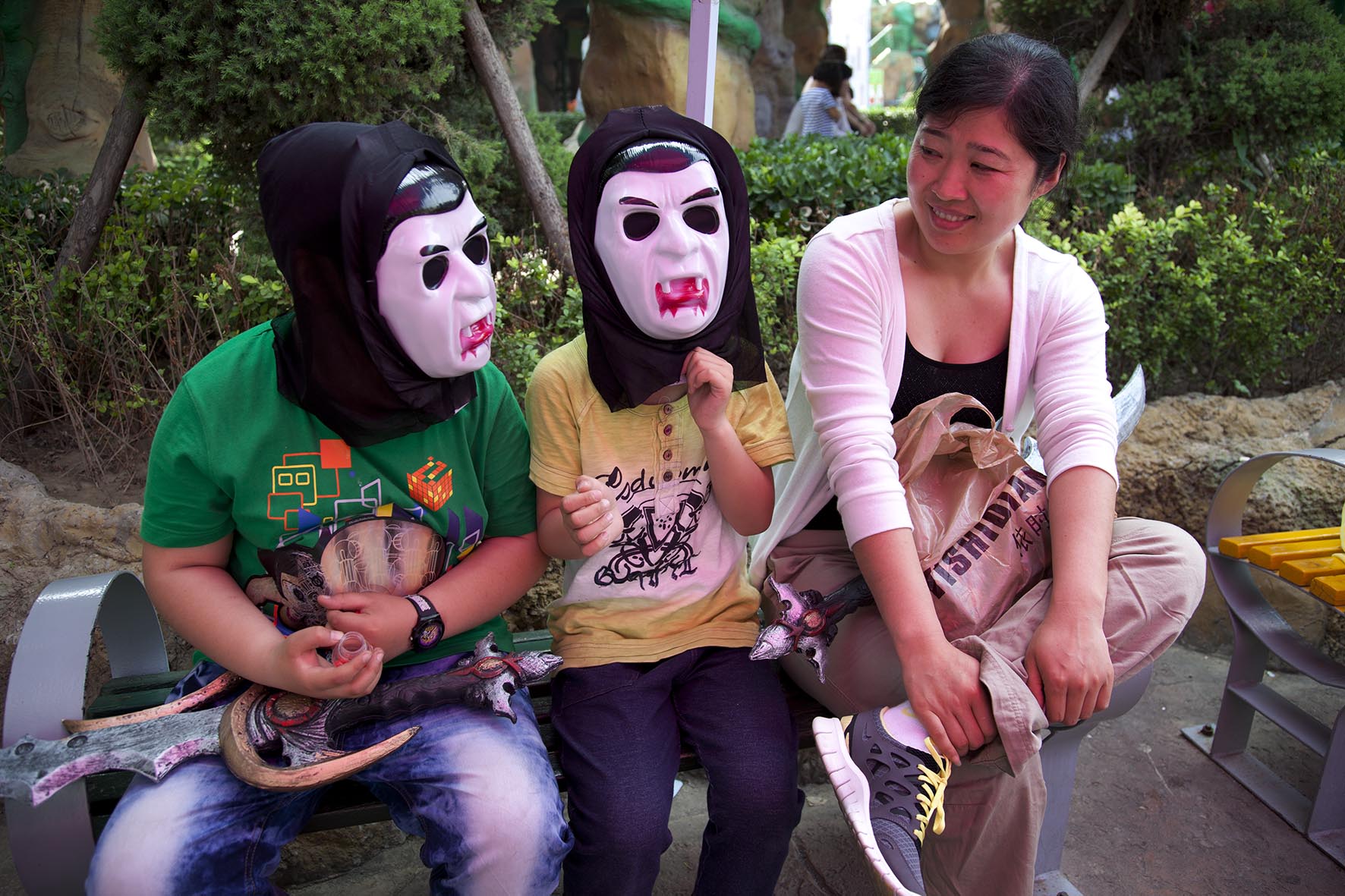  Two children wearing scary dracula horror masks. Happy Valley Beijing is an amusement park. 