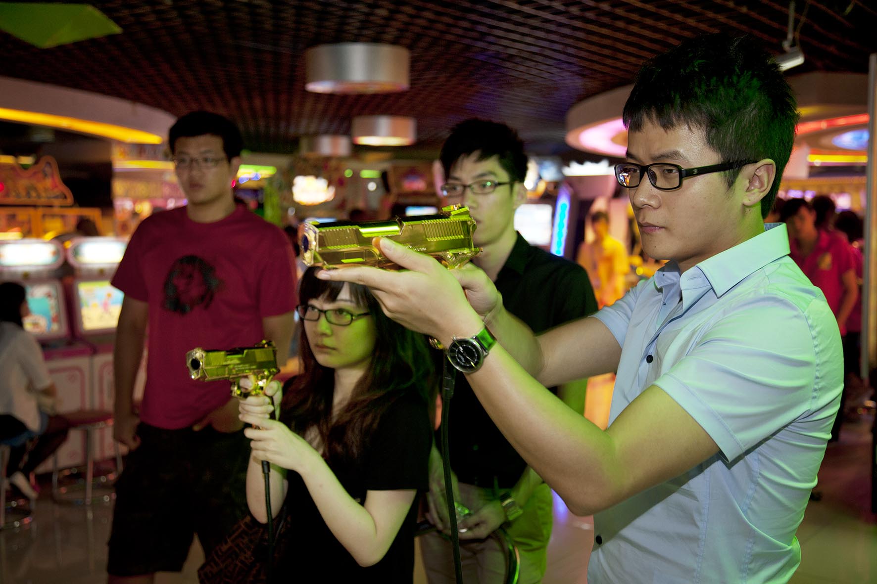  Young people playing a computer shooting game in an amusement arcarde in Joy City shopping mall. 