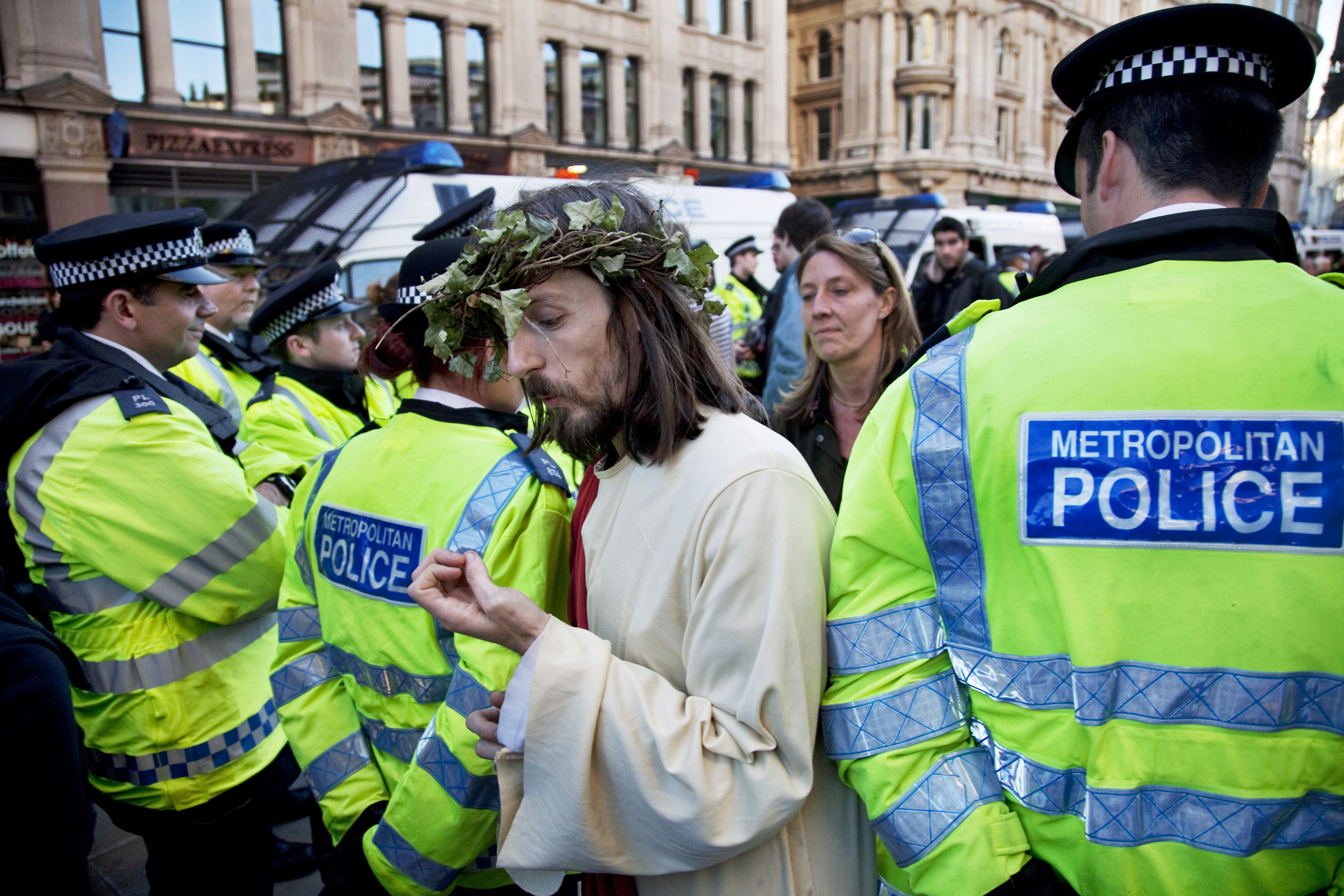  As Jesus walks through police lines at the Occupy London protest, he checks his nails. 
