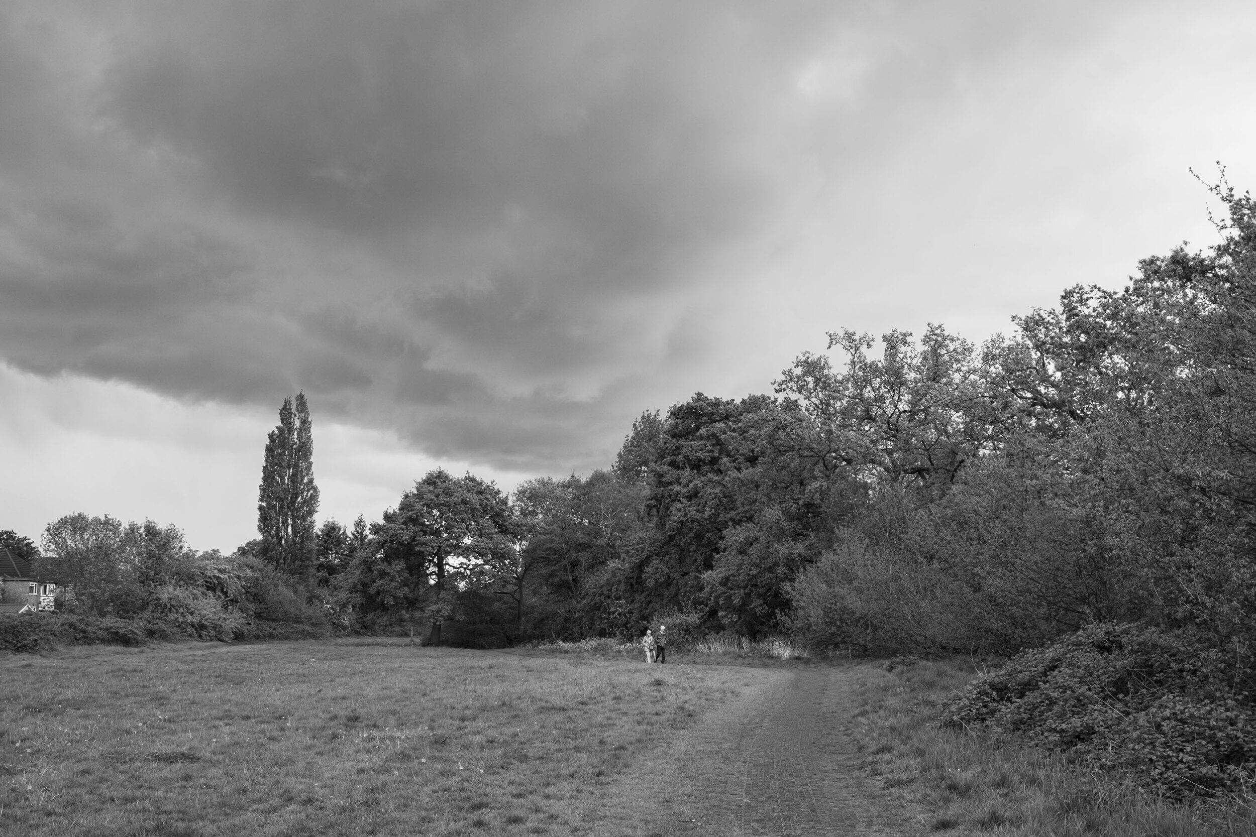  Elderly couple out walking as a storm approaches near Chinn Brook. May 2020. Billesley. 