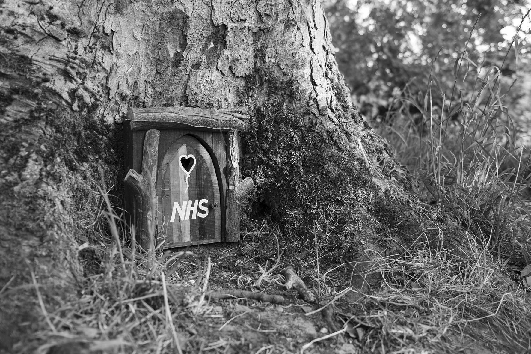  Tiny wooden ‘fairy’ door attached to a tree, with a heart shaped hole in support of NHS workers during the Coronavirus pandemic in Highbury Park. May 2020. Kings Heath. 