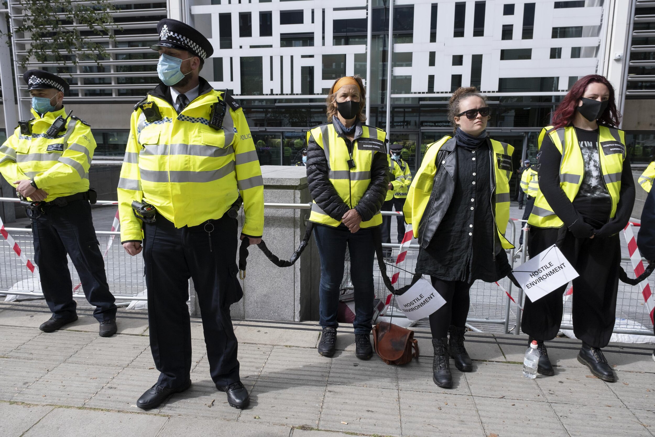  Climate justice protesters dressed as a 'Hostile Environment Border Force' chained together at a demonstration outside the Home Office in solidarity with migrants and those who suffer because of migration systems wordwide. 