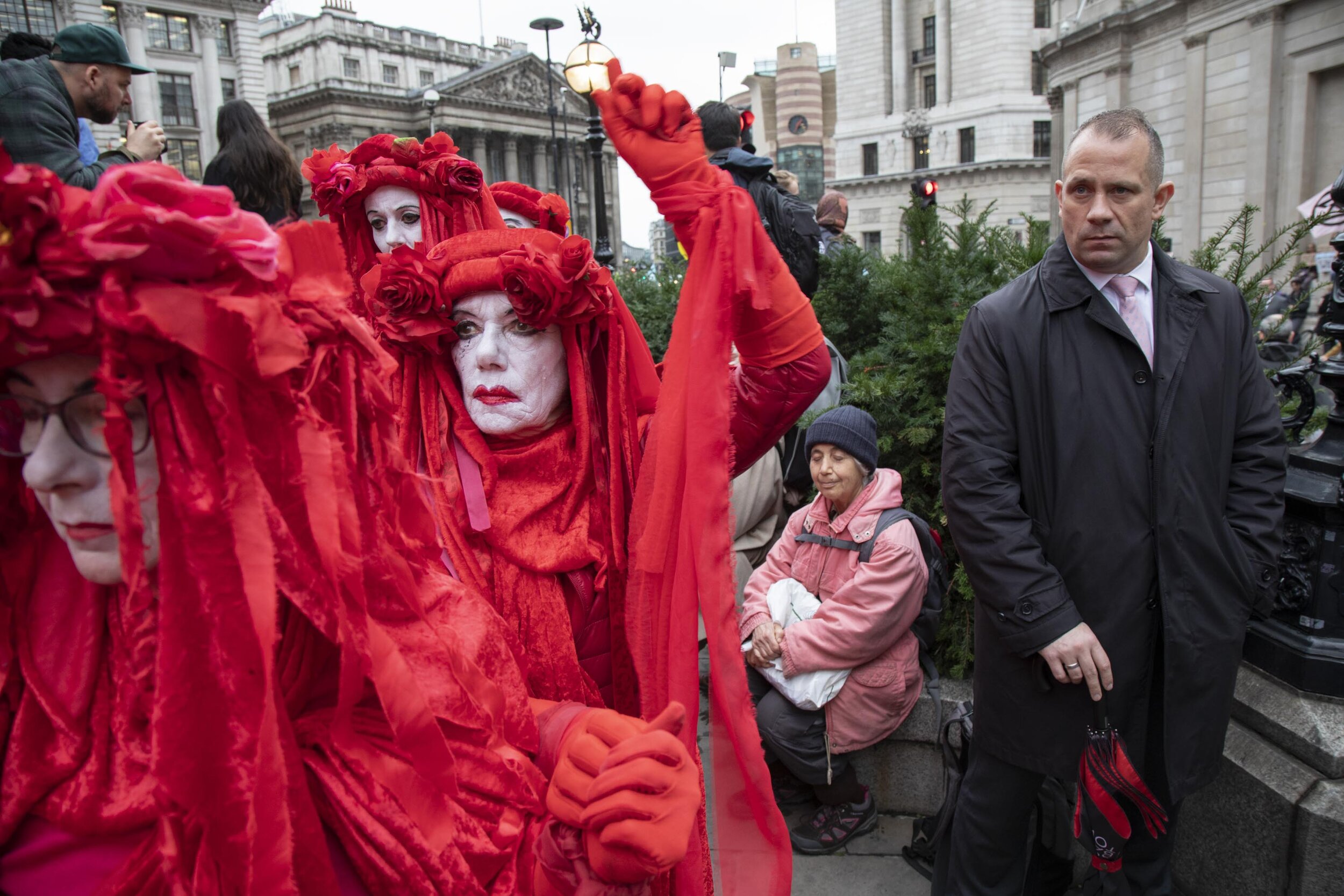  Climate change activist performance art troupe the 'Red Rebel Brigade' march silently at Bank in the heart of the City of London financial district. 