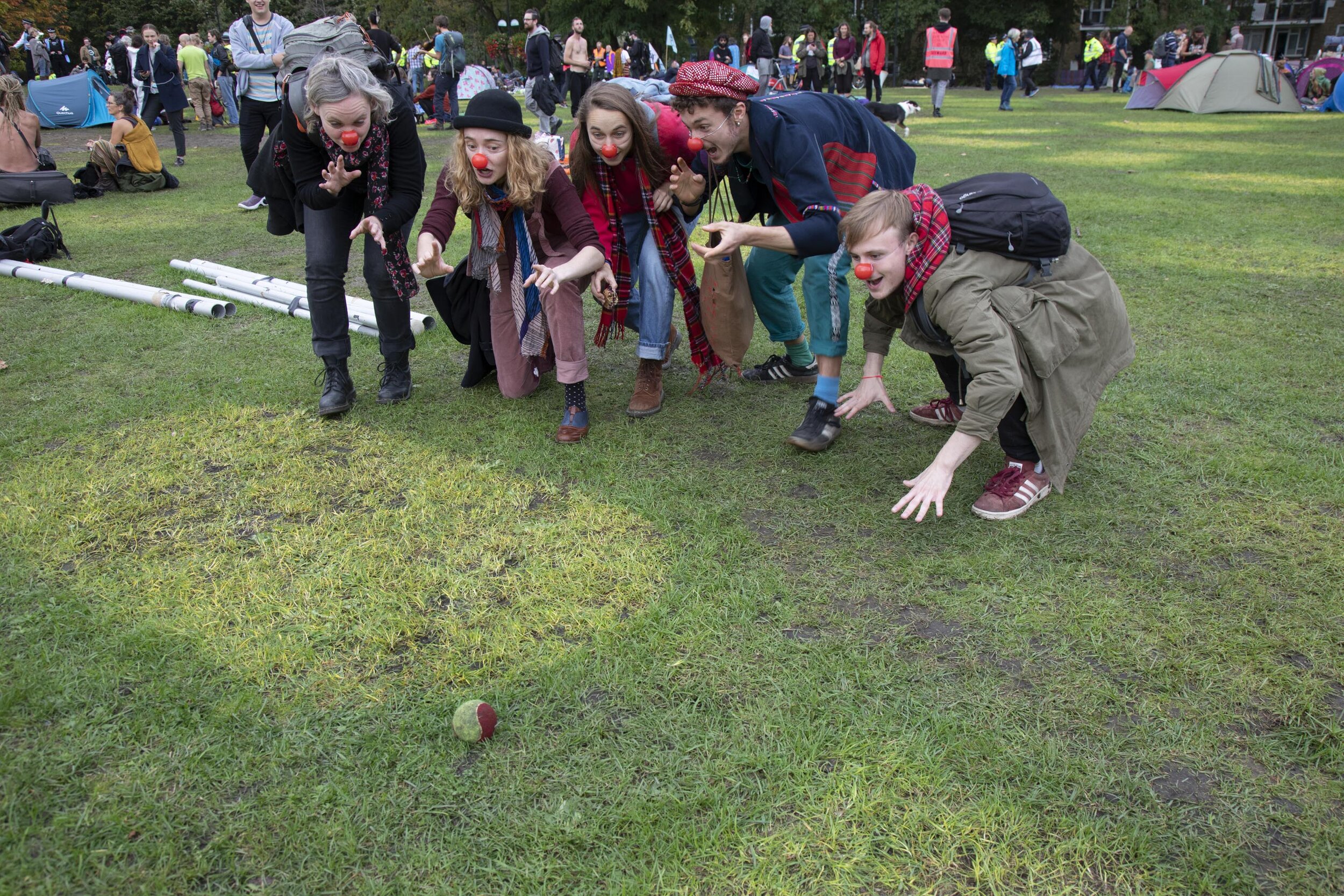 Activists wearing red noses play a game where they pretend to creep up on a tennis ball as the climate camp at Vauxhall is cleared. 