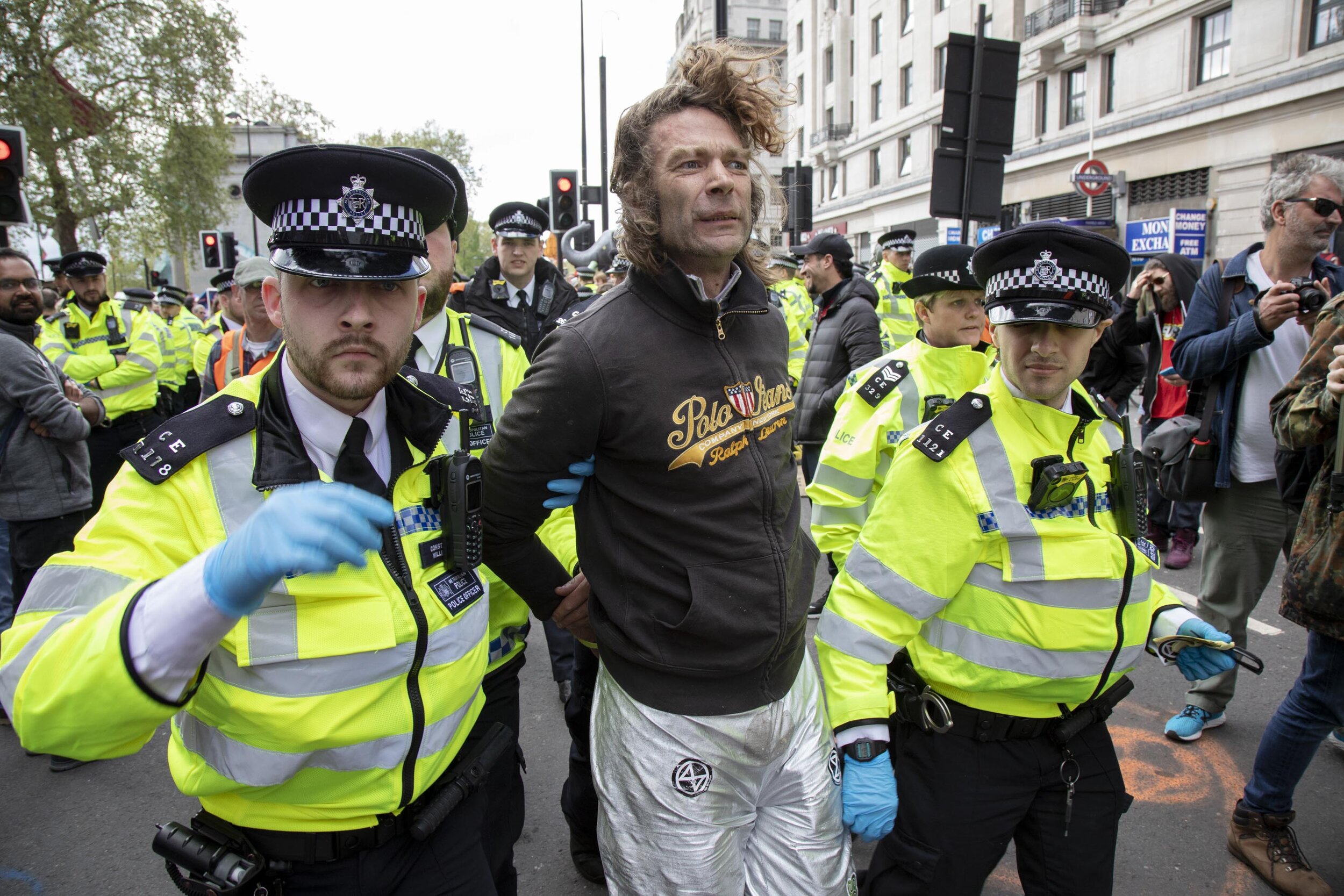  Police struggle with and arrest and remove a protester as they try to clear climate change activists at Oxford Street near to the Marble Arch camp. 