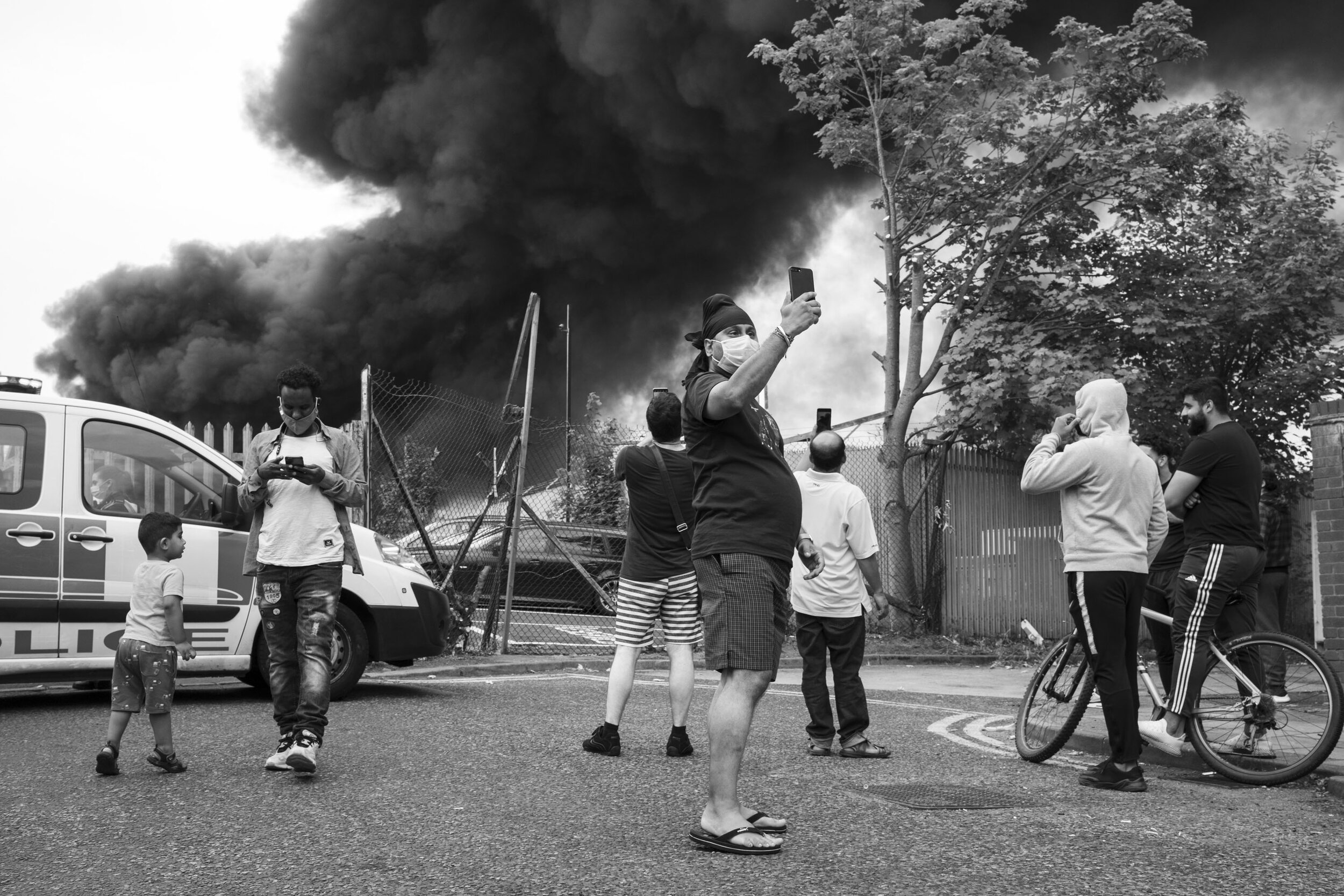  Local people gather to witness a large scale fire at a plastics factory at Tyseley Industrial Estate. August 2020. Tyseley. 